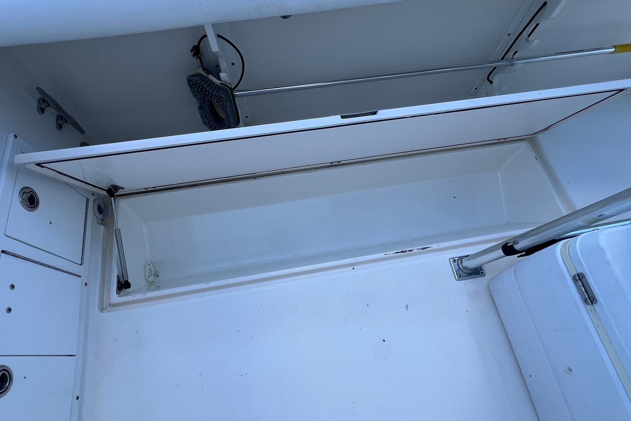 Open storage compartment on a 2006 Edgewater 245CC boat, showcasing interior space.