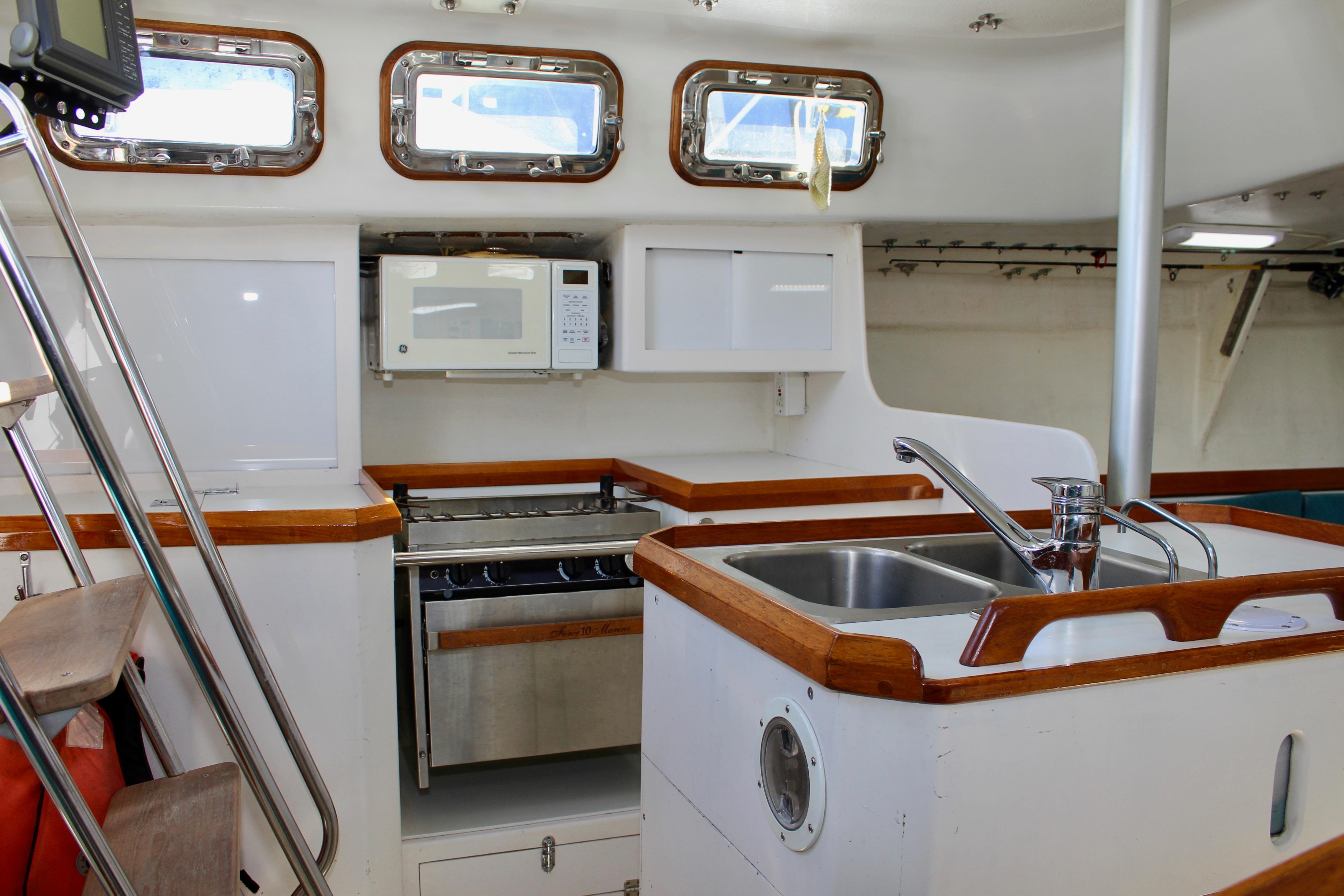 Interior of 1993 Freya 39 sailboat kitchen with sink, stove, and microwave.