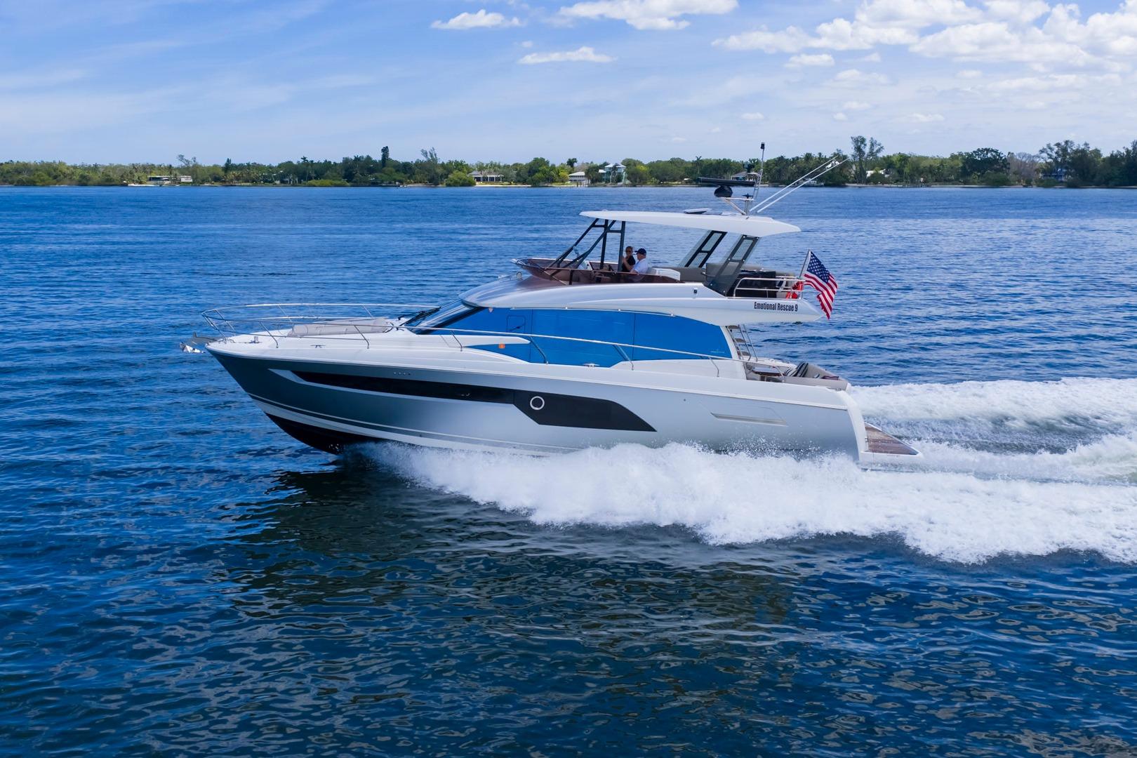 2022 Prestige 520 yacht cruising on blue water under a clear sky.