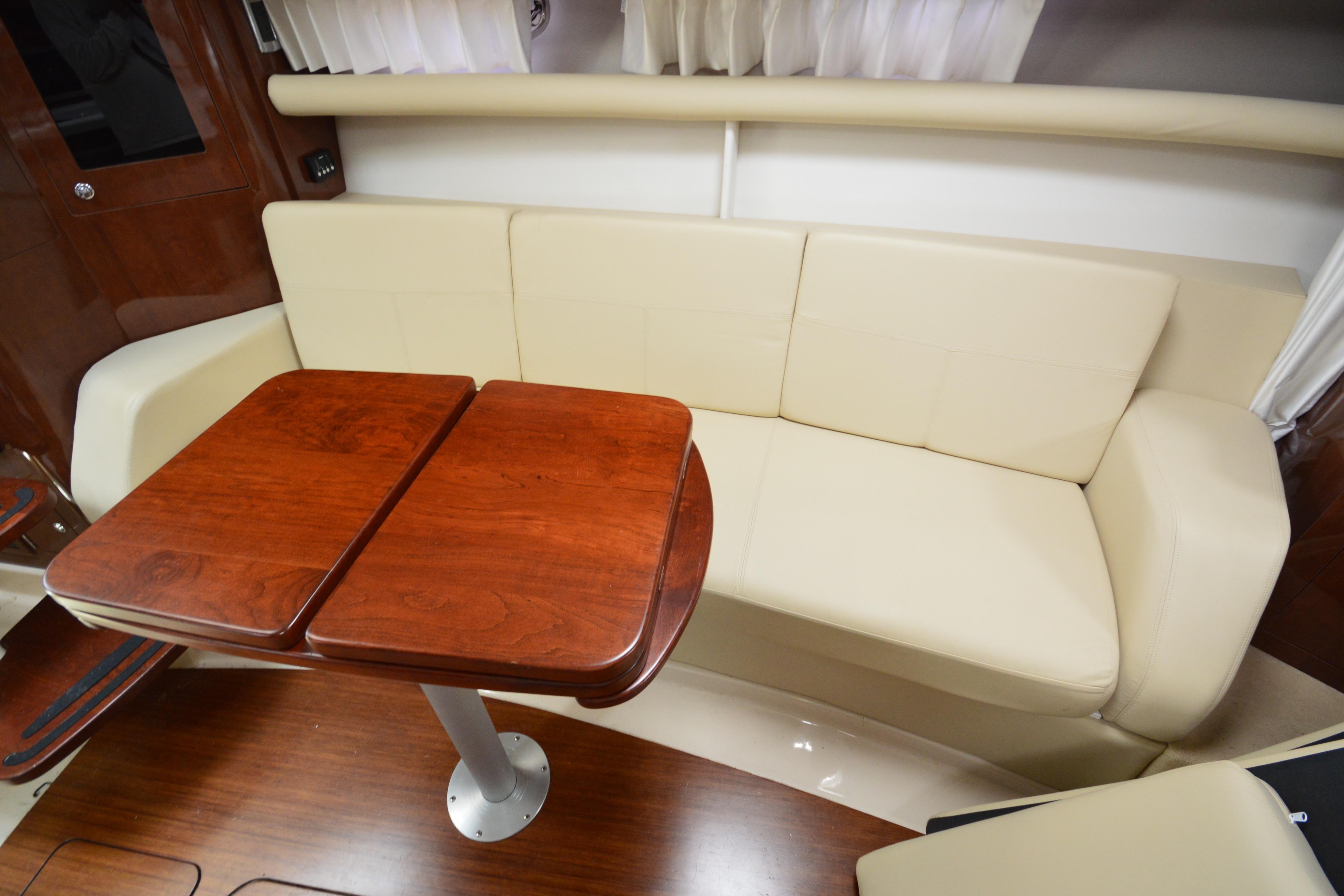 Luxurious interior of 2013 Four Winns V375 yacht with cream sofa and wooden table.