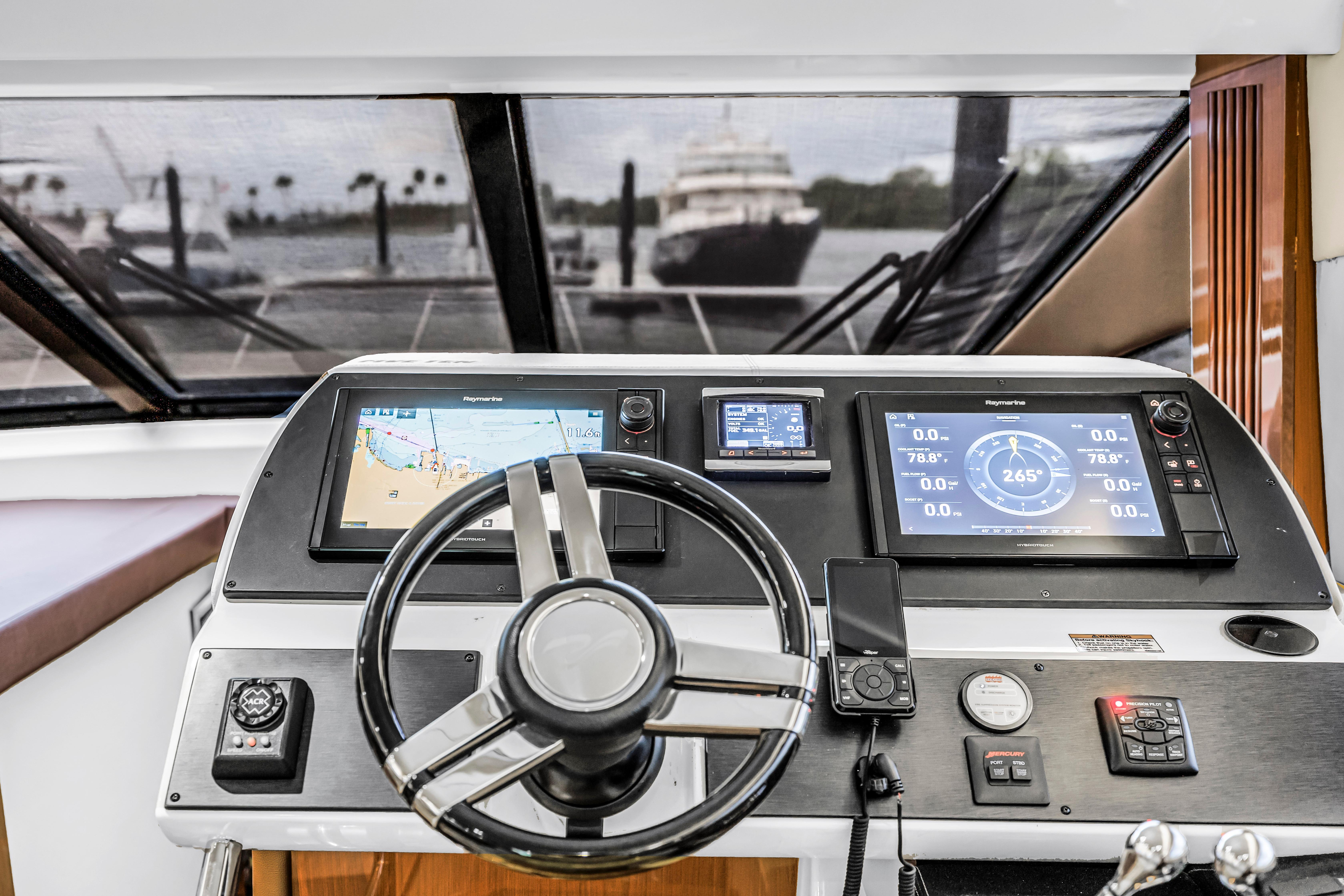 Helm of 2016 Sea Ray 510 Fly yacht with navigation displays and steering wheel.