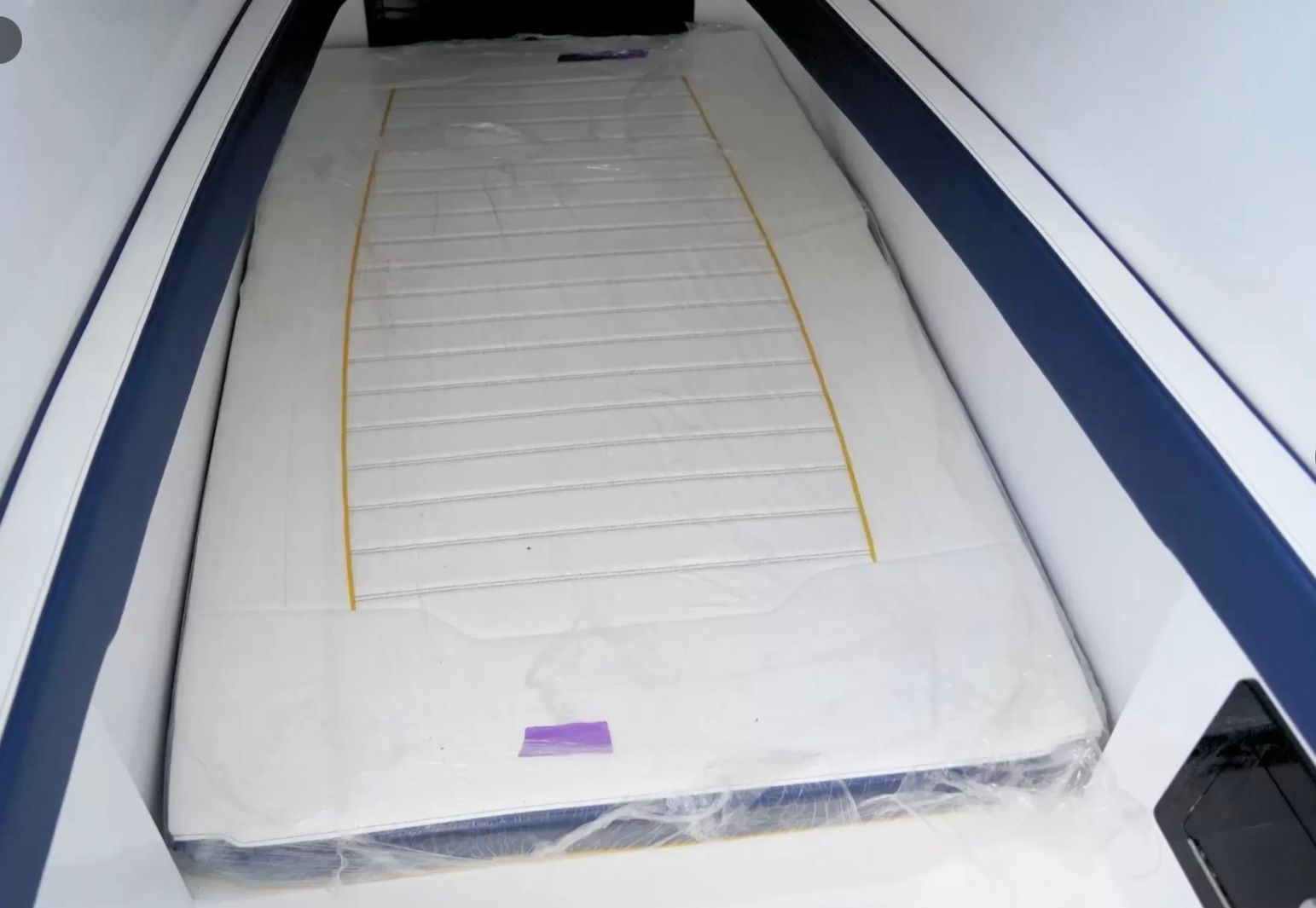 Interior of a boat with a cushioned sleeping area.