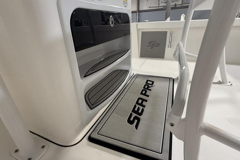 2026 Sea Pro 250 Bay boat interior with branded mat and storage compartments.