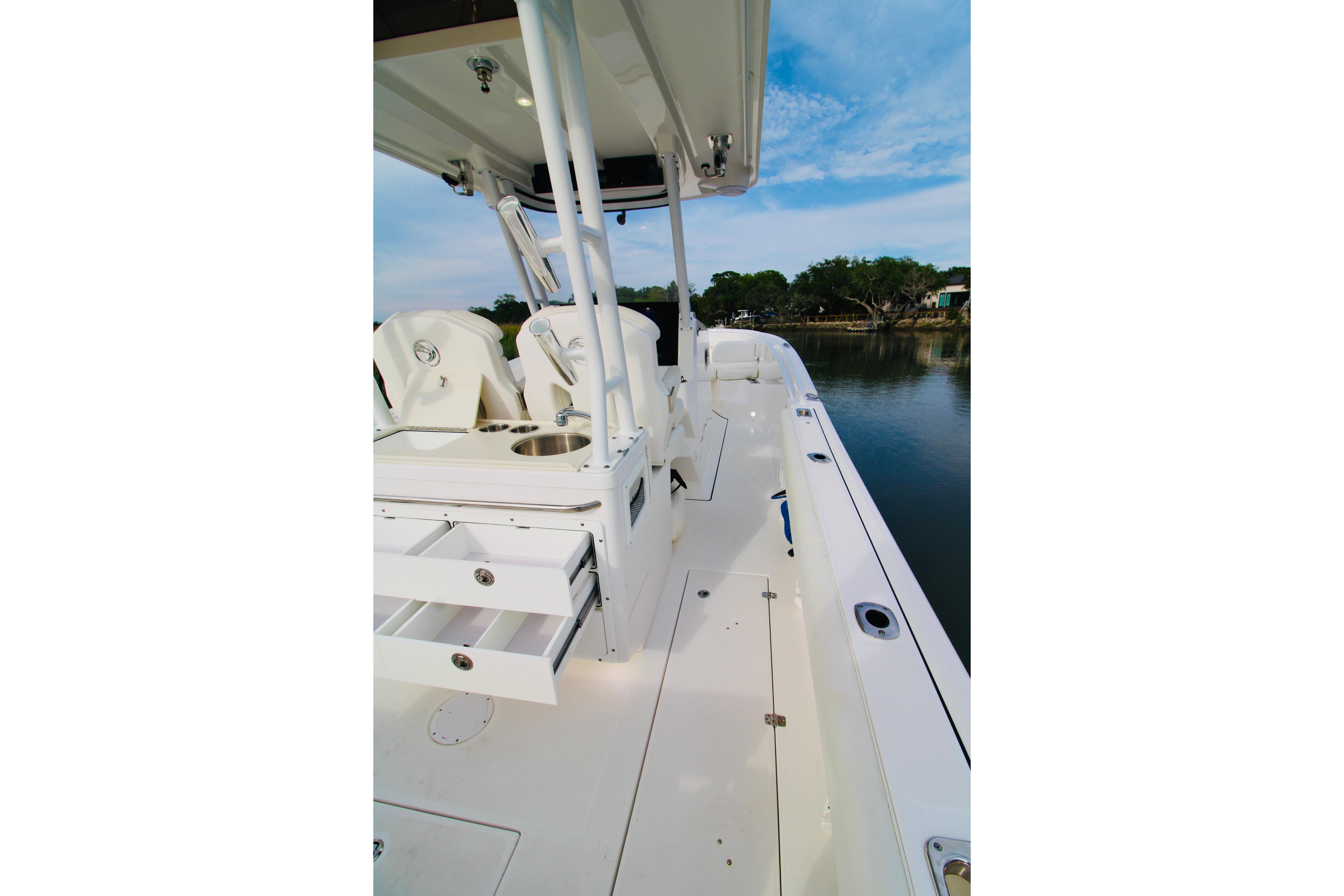 2022 Edgewater 280CC boat interior with seating and storage, docked by calm water.