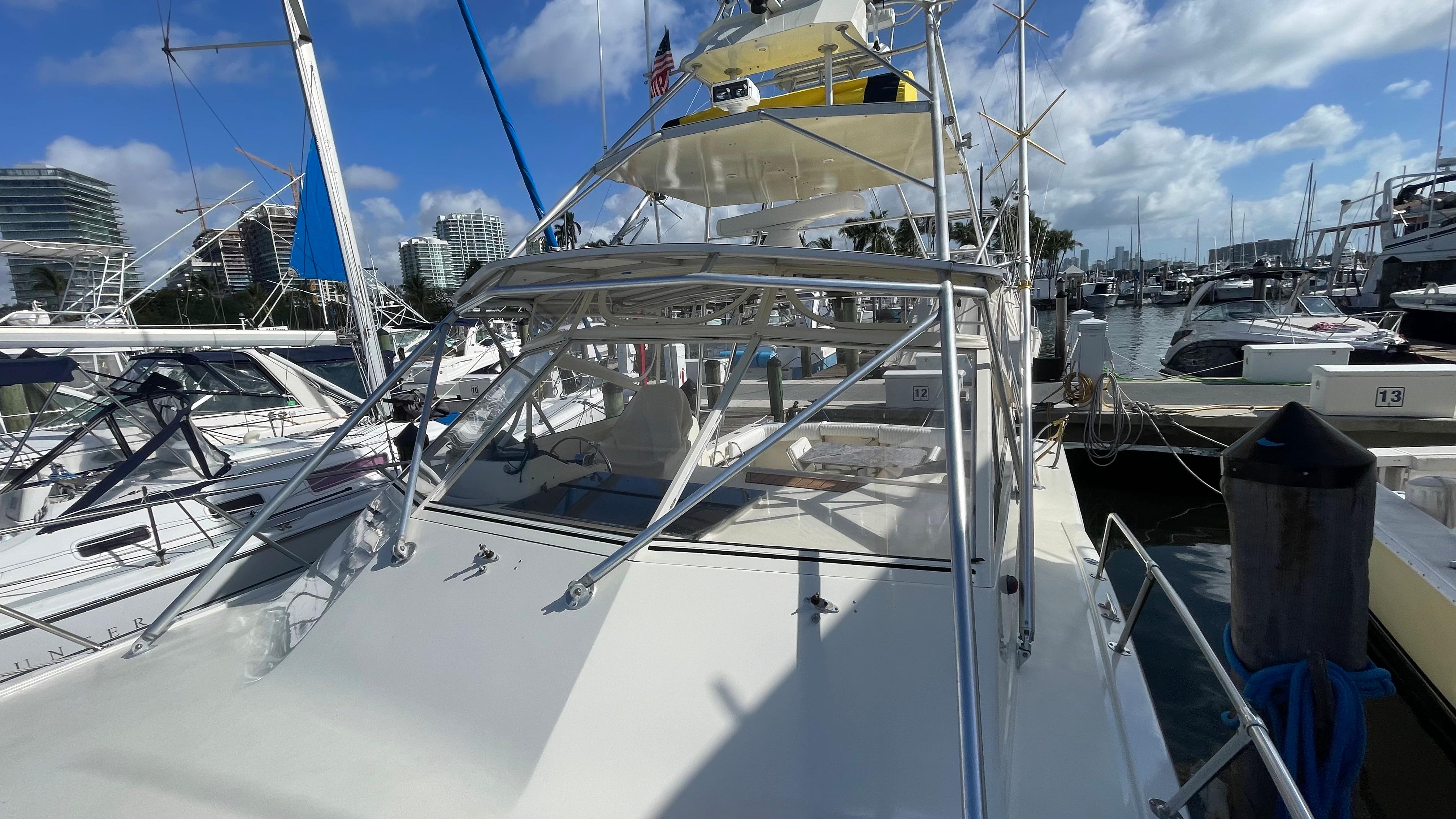1985 Hatteras 36 Convertible yacht docked at a marina on a sunny day.