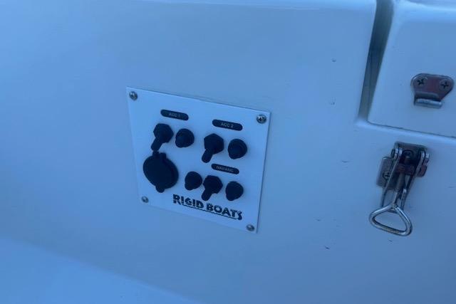 Control panel on 2024 Rigid Boats 10 Sport, featuring switches and a latch.