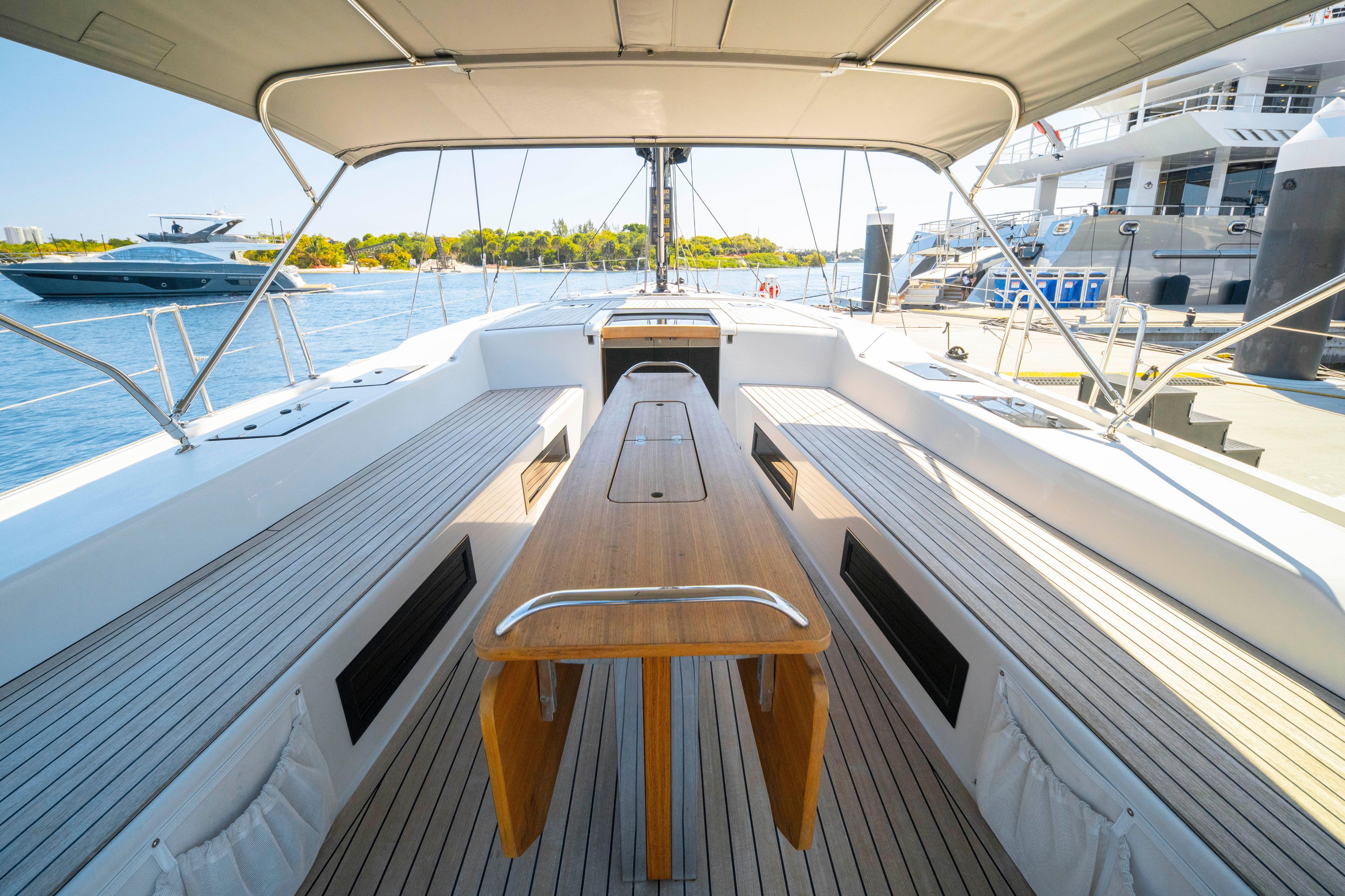 Spacious deck of 2016 Grand Soleil 58 yacht with wooden table and seating.