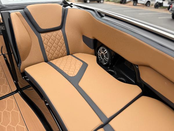 2025 Yamaha Boats 255XD interior with tan and black seating, featuring stylish design and speaker system.