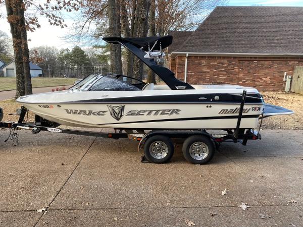 2009 Malibu Wakesetter VTX boat on a trailer in a driveway.