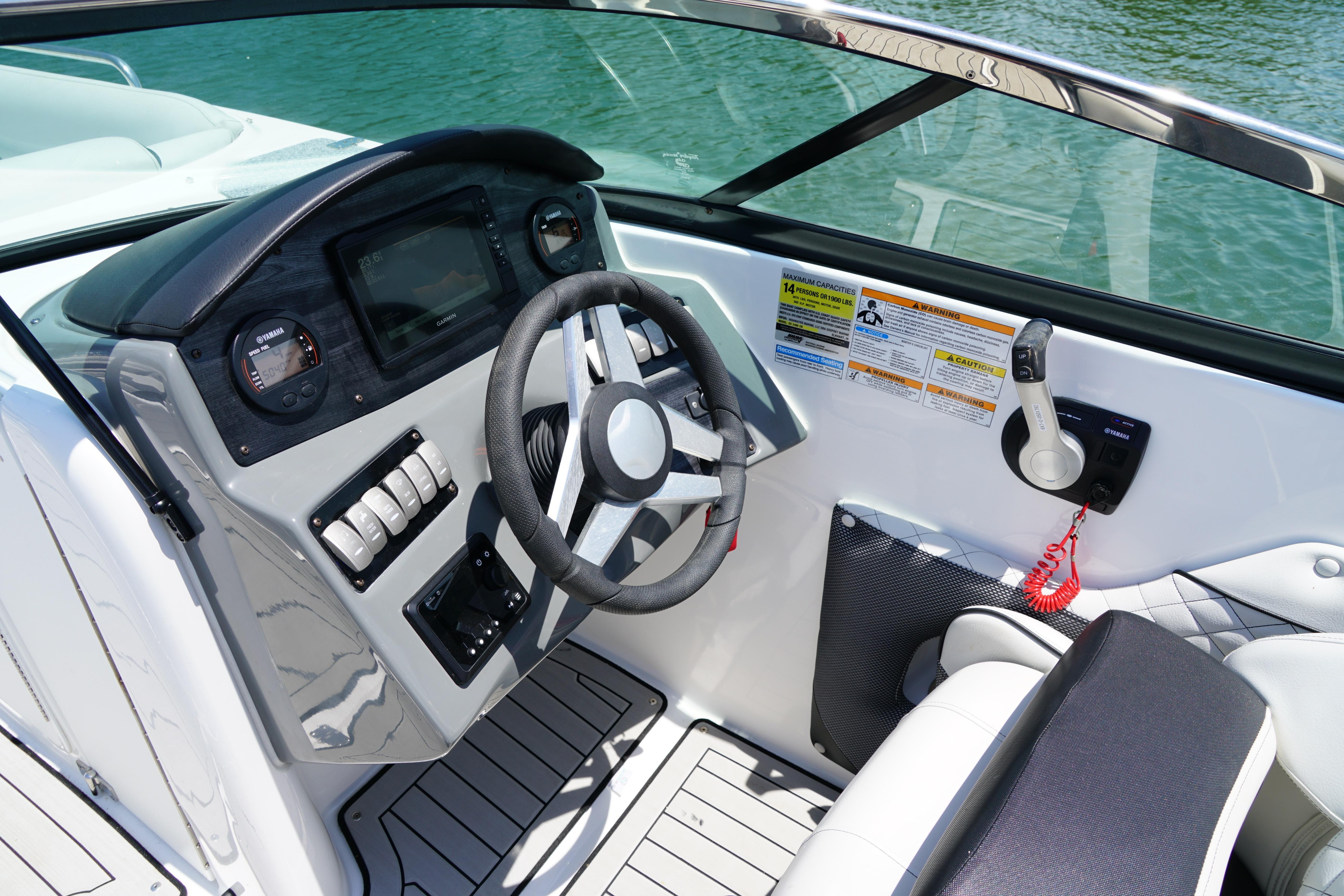 Cockpit of 2020 Hurricane SunDeck 2486 OB boat with steering wheel and controls.