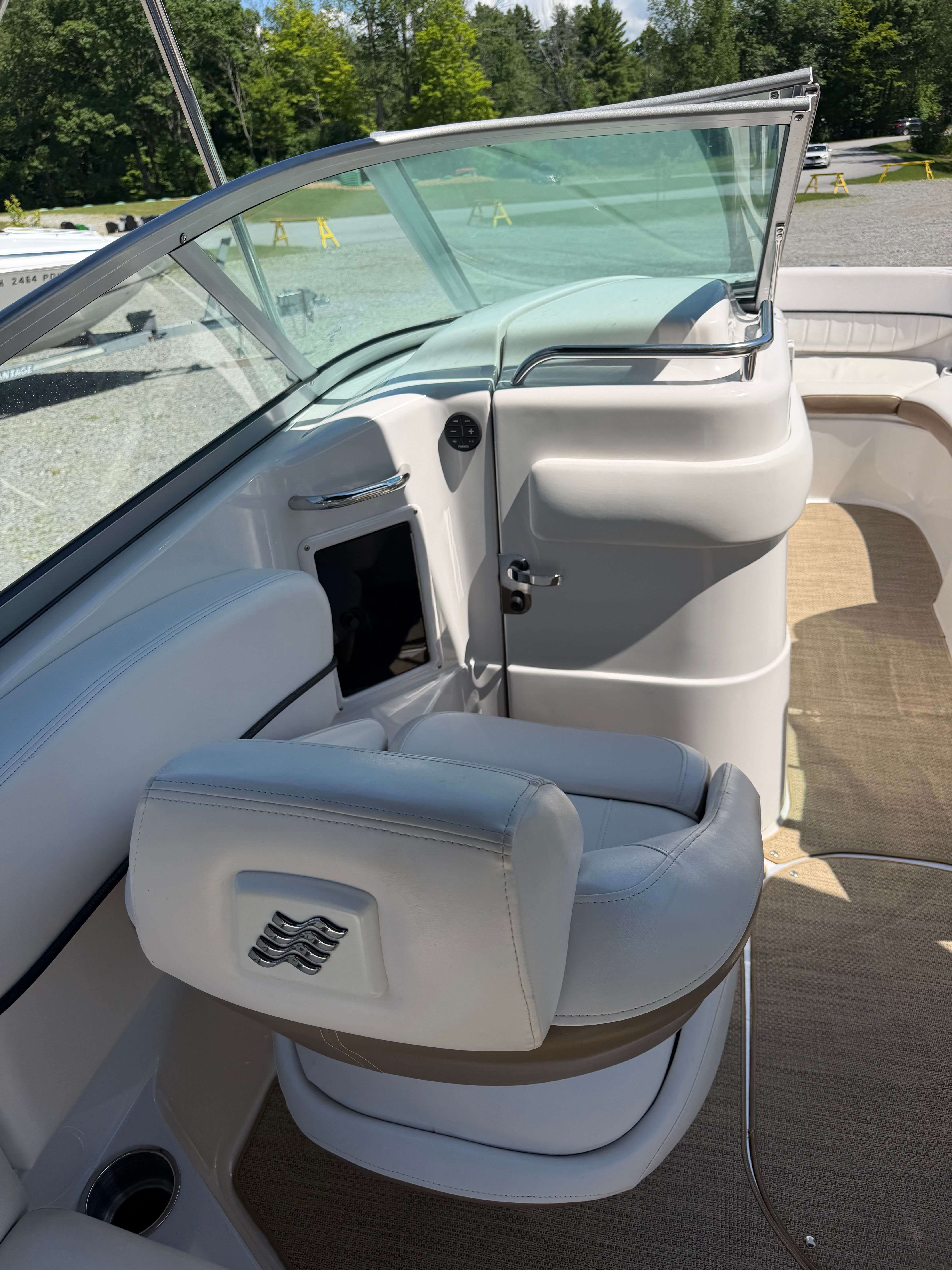 Interior view of a boat with a white seat and helm console.