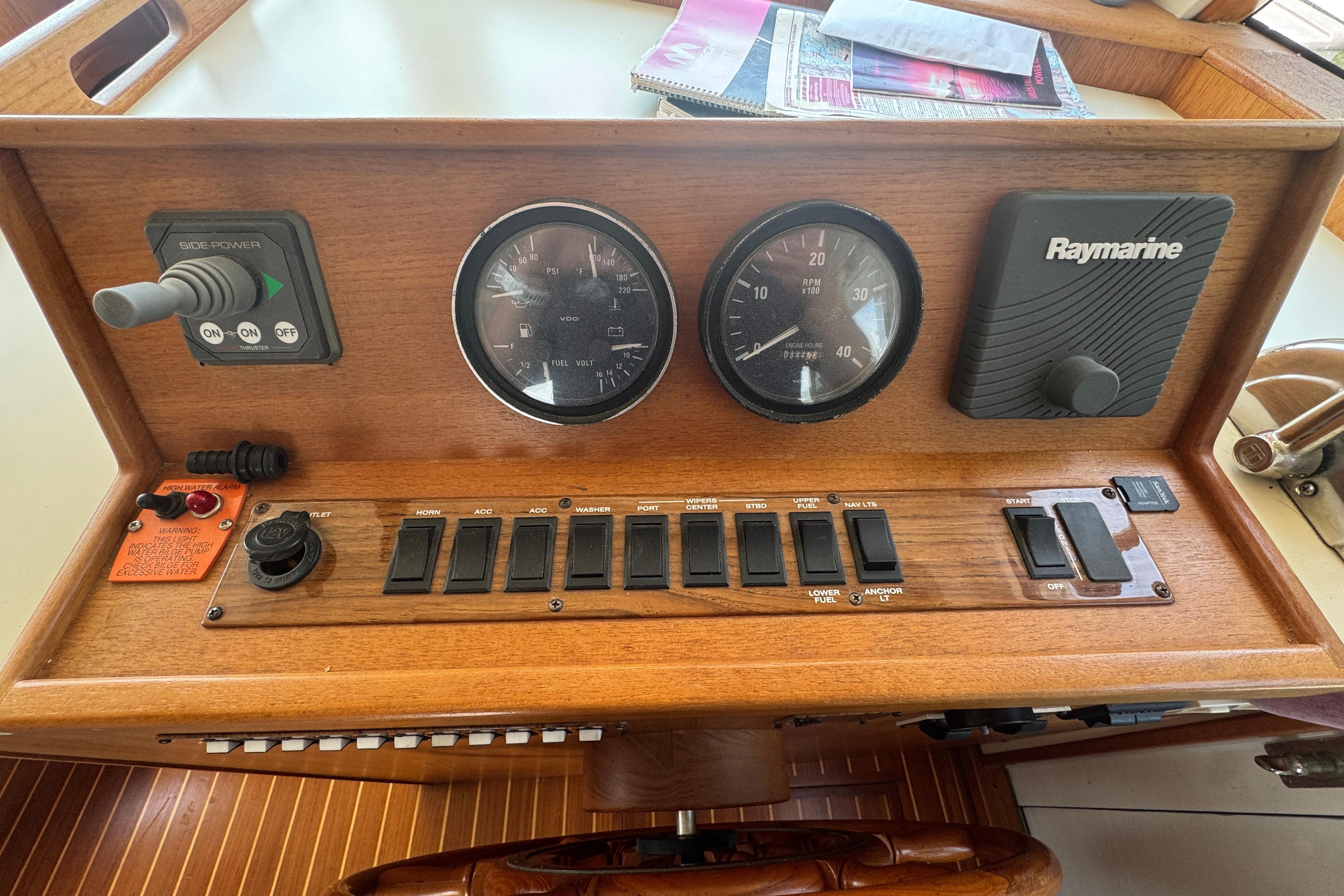 2002 Mainship 390 Trawler dashboard with gauges, switches, and Raymarine equipment.