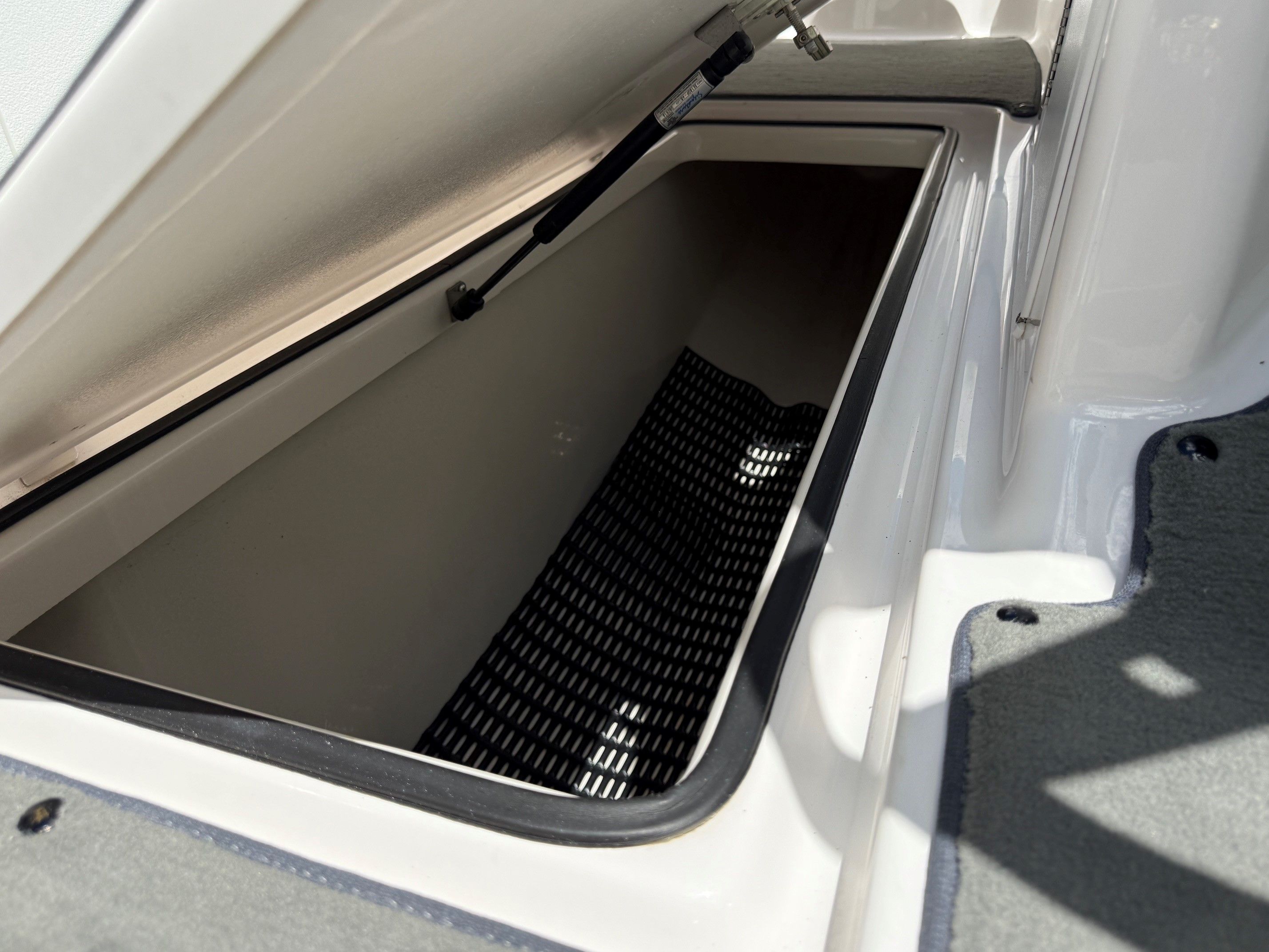 An open storage compartment on a 2017 Yamaha SX210 boat.
