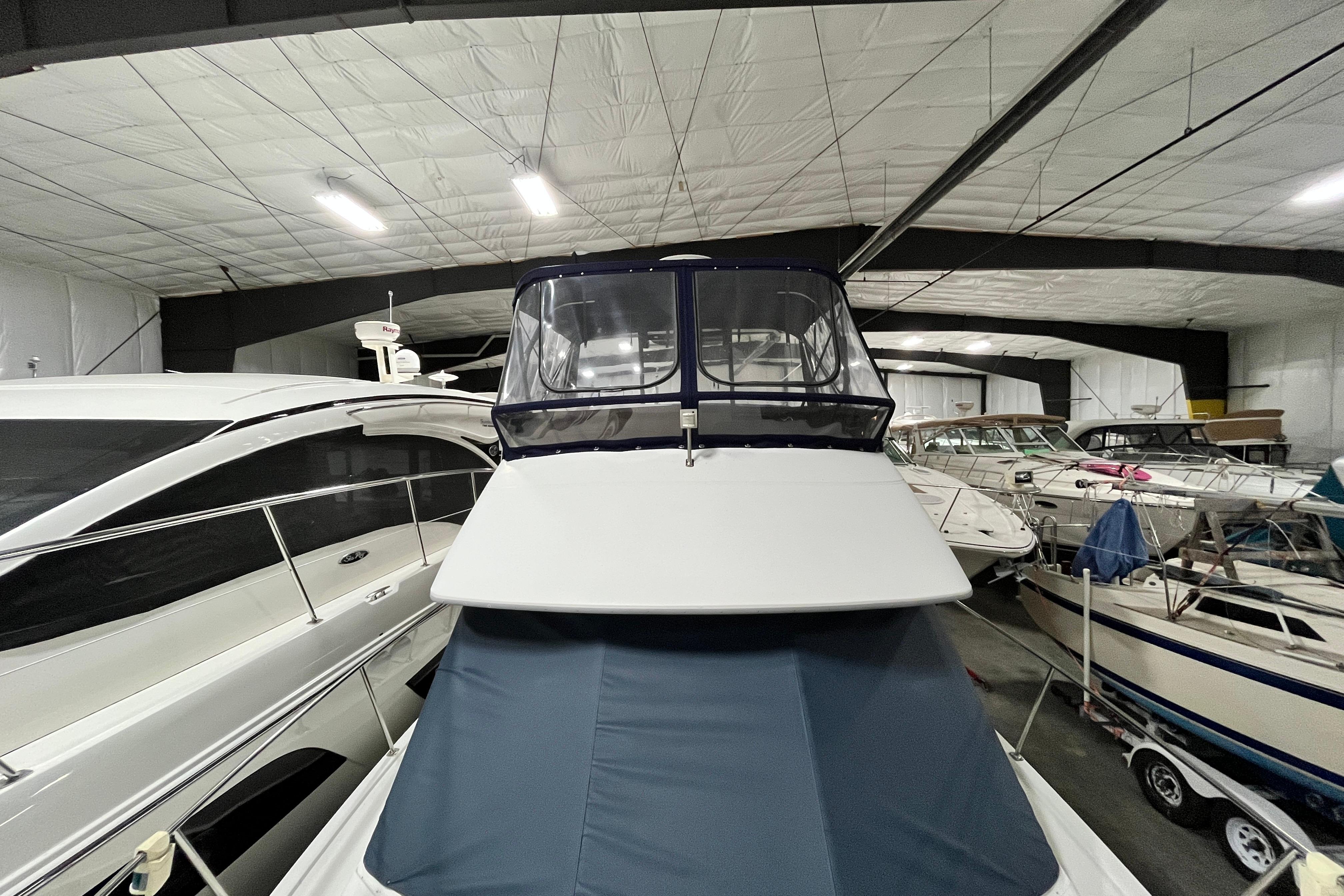 1995 Carver 325 Aft Cabin Motor Yacht in indoor storage, surrounded by other boats.