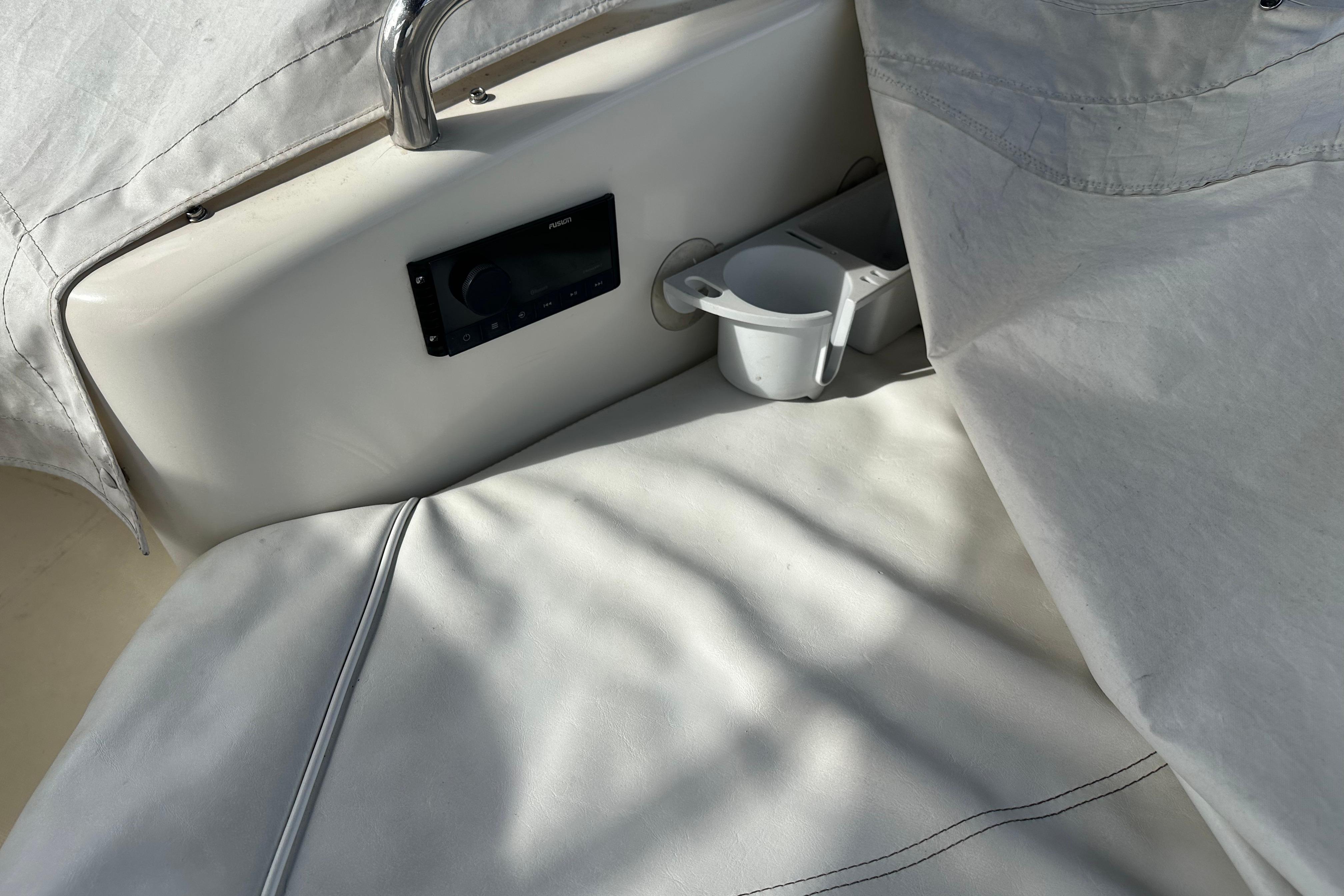 Interior of 2004 Azimut 55E yacht with white seating and cup holder.