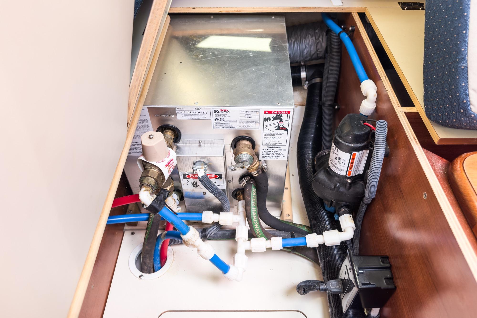 Interior view of a 2015 Hunter 33 boat's plumbing system with pipes and valves.
