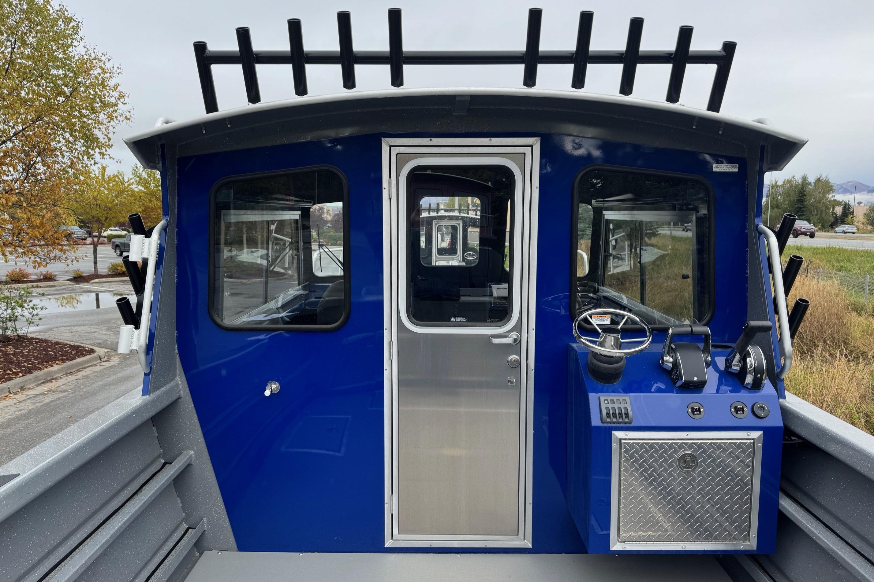 2024 Spartan 26 Maximus Pro XL boat with blue cabin and steering controls.