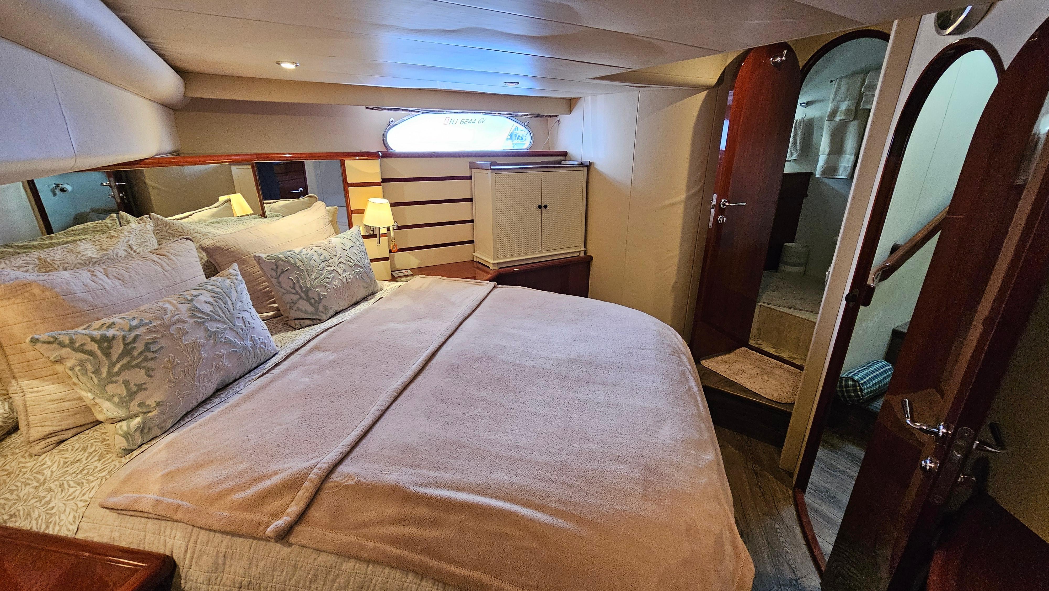 Luxurious bedroom interior of 2005 Neptunus 56 Flybridge yacht with cozy bedding.