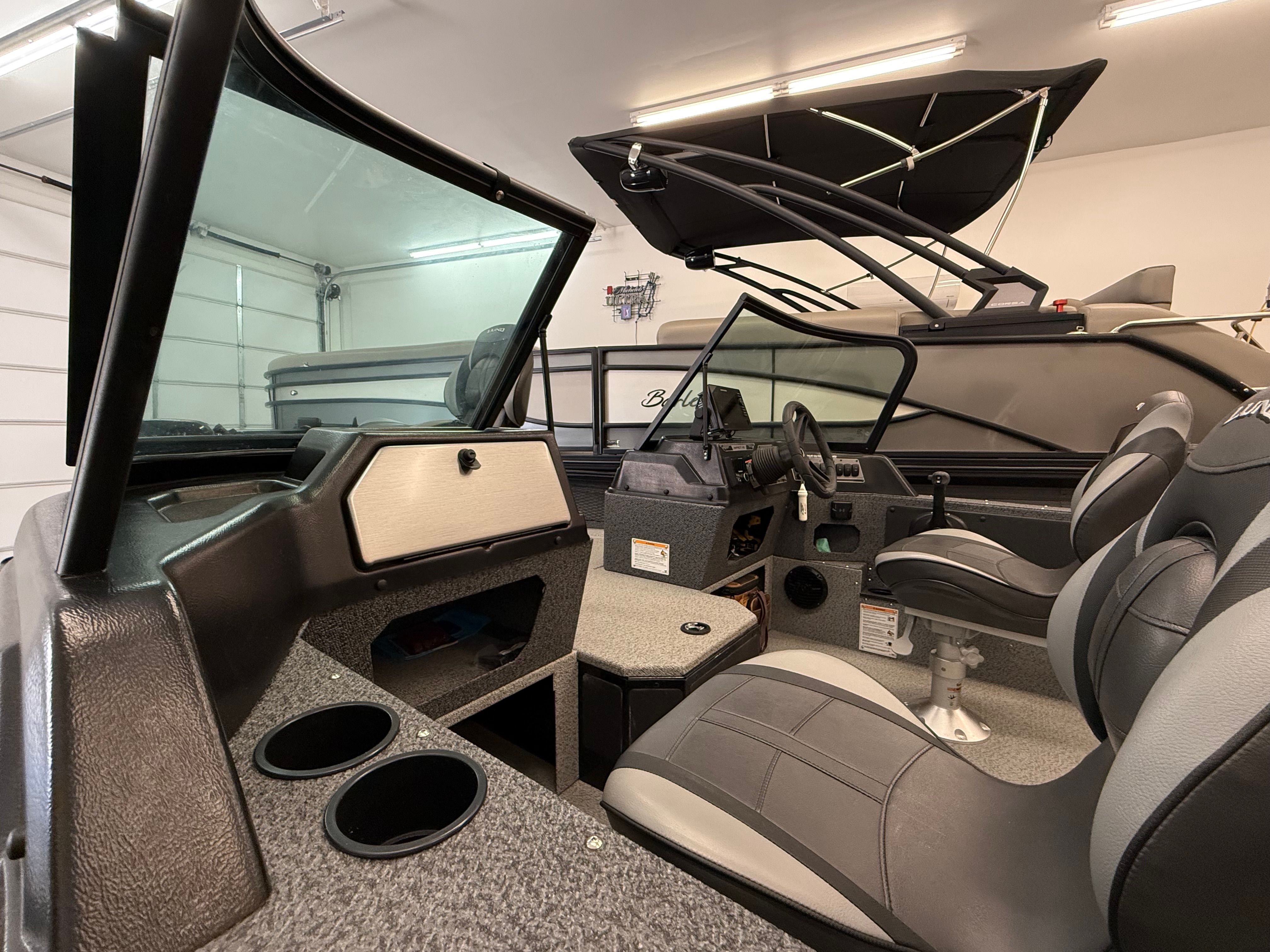 Interior view of a 2025 Lund 1875 Impact XS Sport boat with modern seating and helm console.
