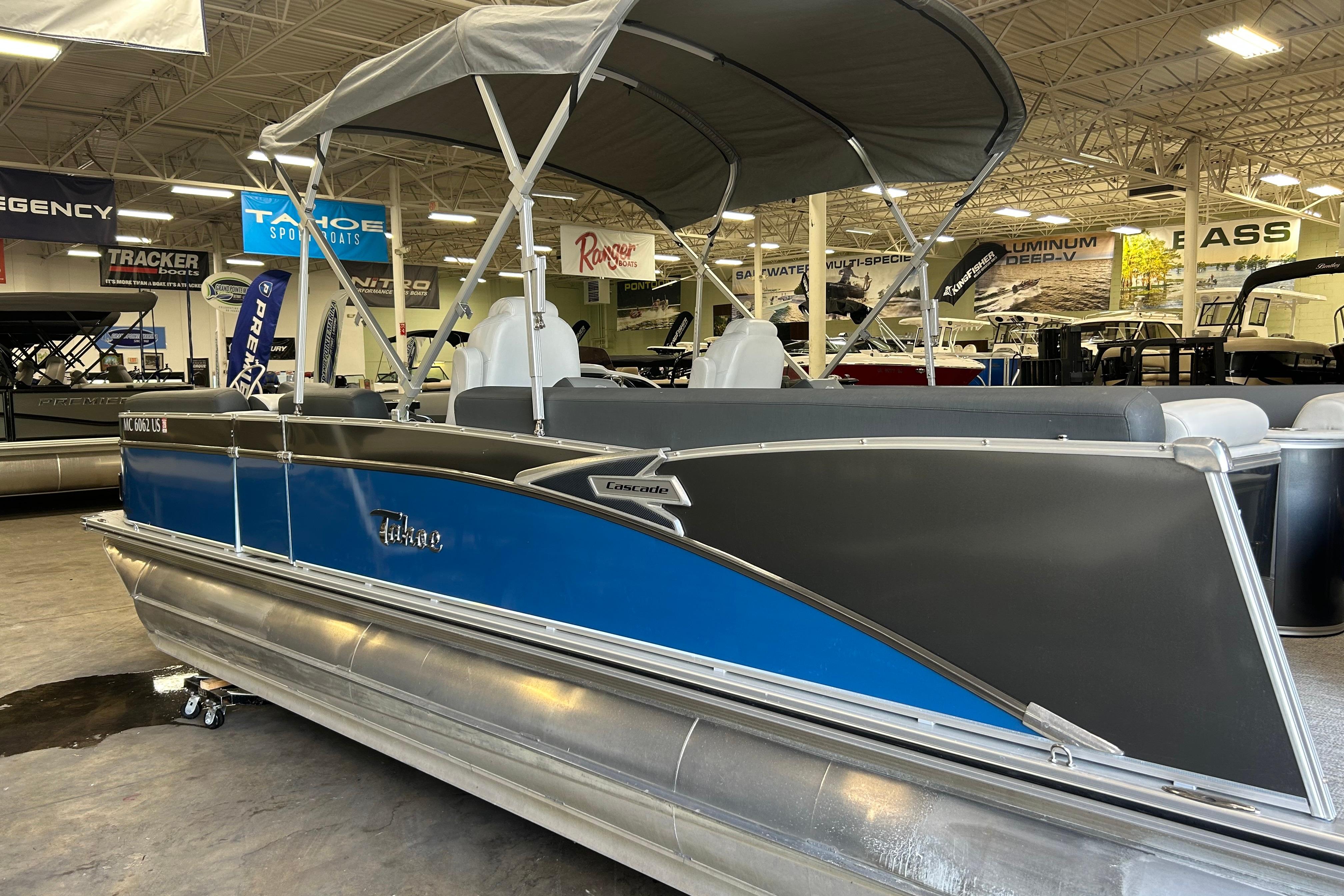 2022 Tahoe Pontoon Cascade Quad Lounger in showroom, featuring sleek blue and gray design.