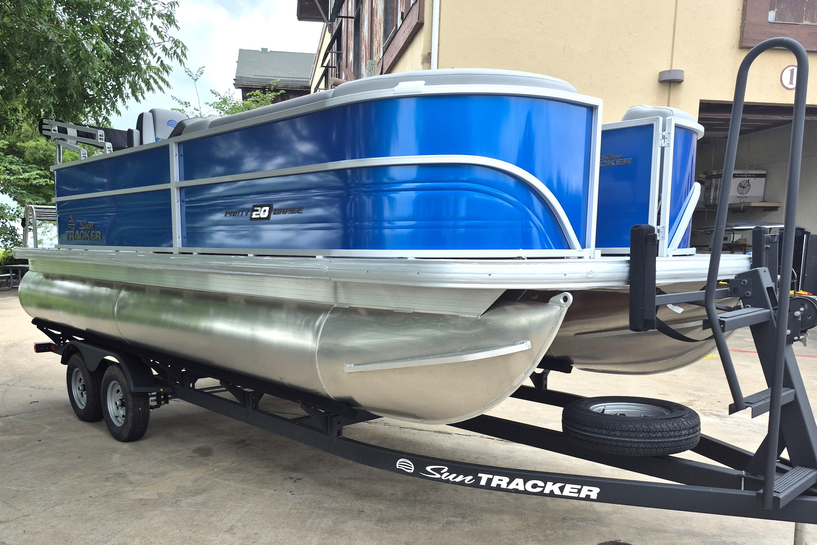 2026 Sun Tracker Party Barge 20 DLX pontoon boat on trailer, blue exterior.