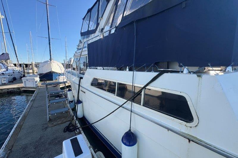 1987 Tollycraft 34 Sundeck Motor Yacht docked at marina, side view.