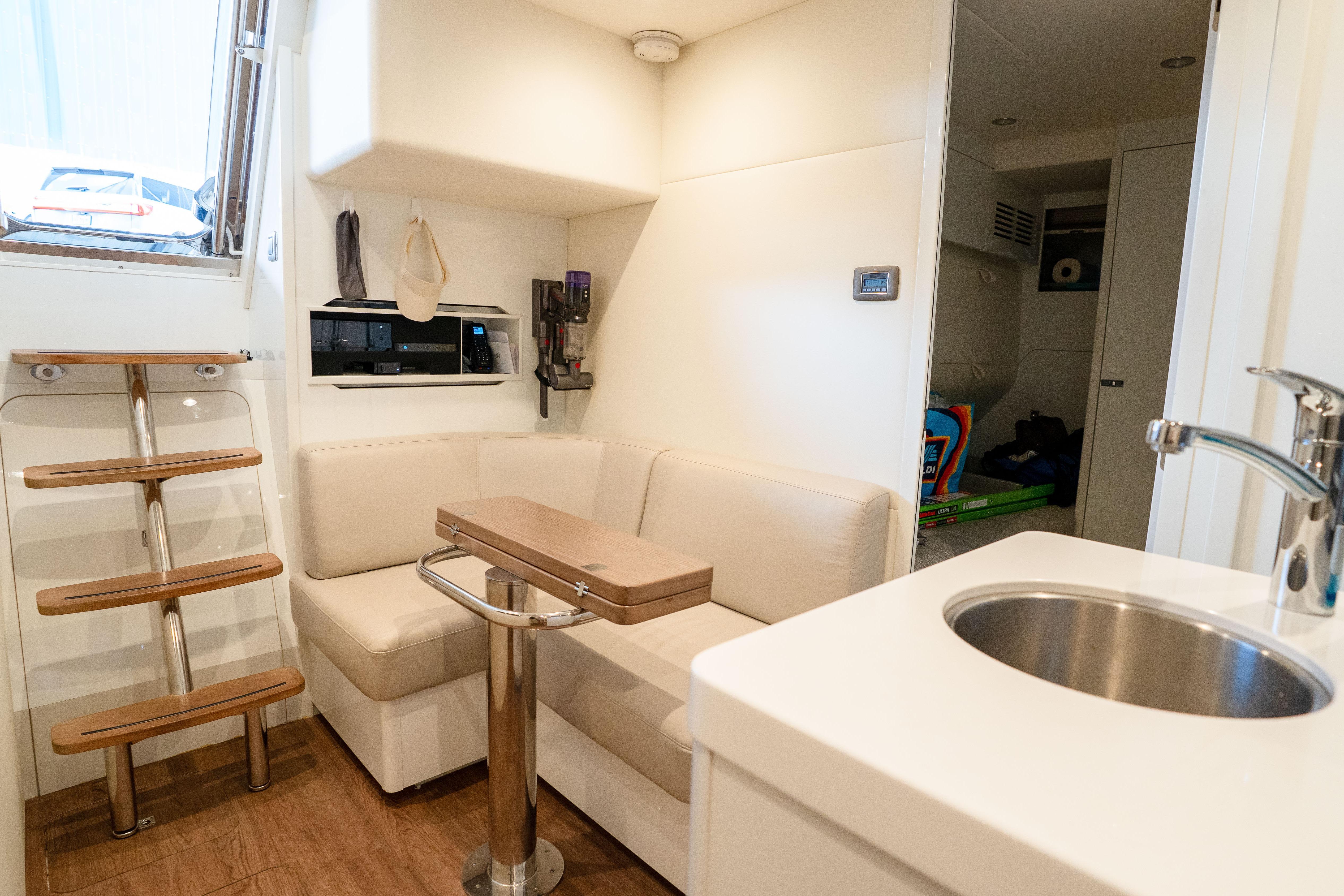 Luxurious interior of 2020 Princess Y85 yacht with modern seating and kitchenette.