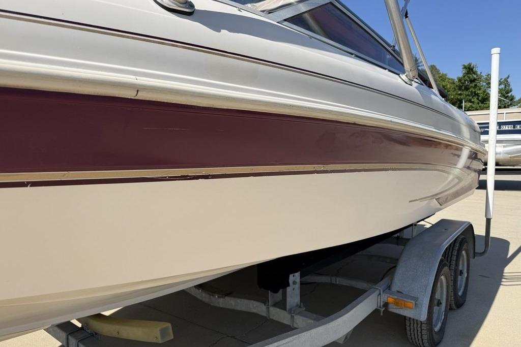 1999 Glastron GT 225 boat on trailer, featuring maroon and white exterior.
