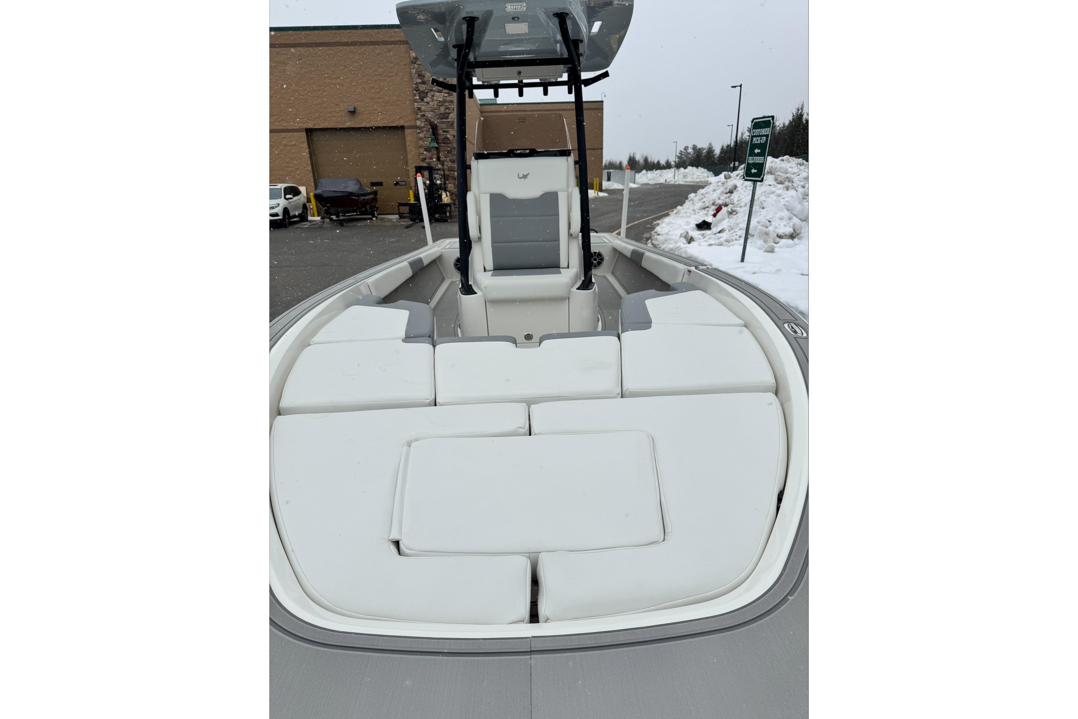 2026 Mako 24 APEX boat with spacious seating, parked in snowy outdoor setting.