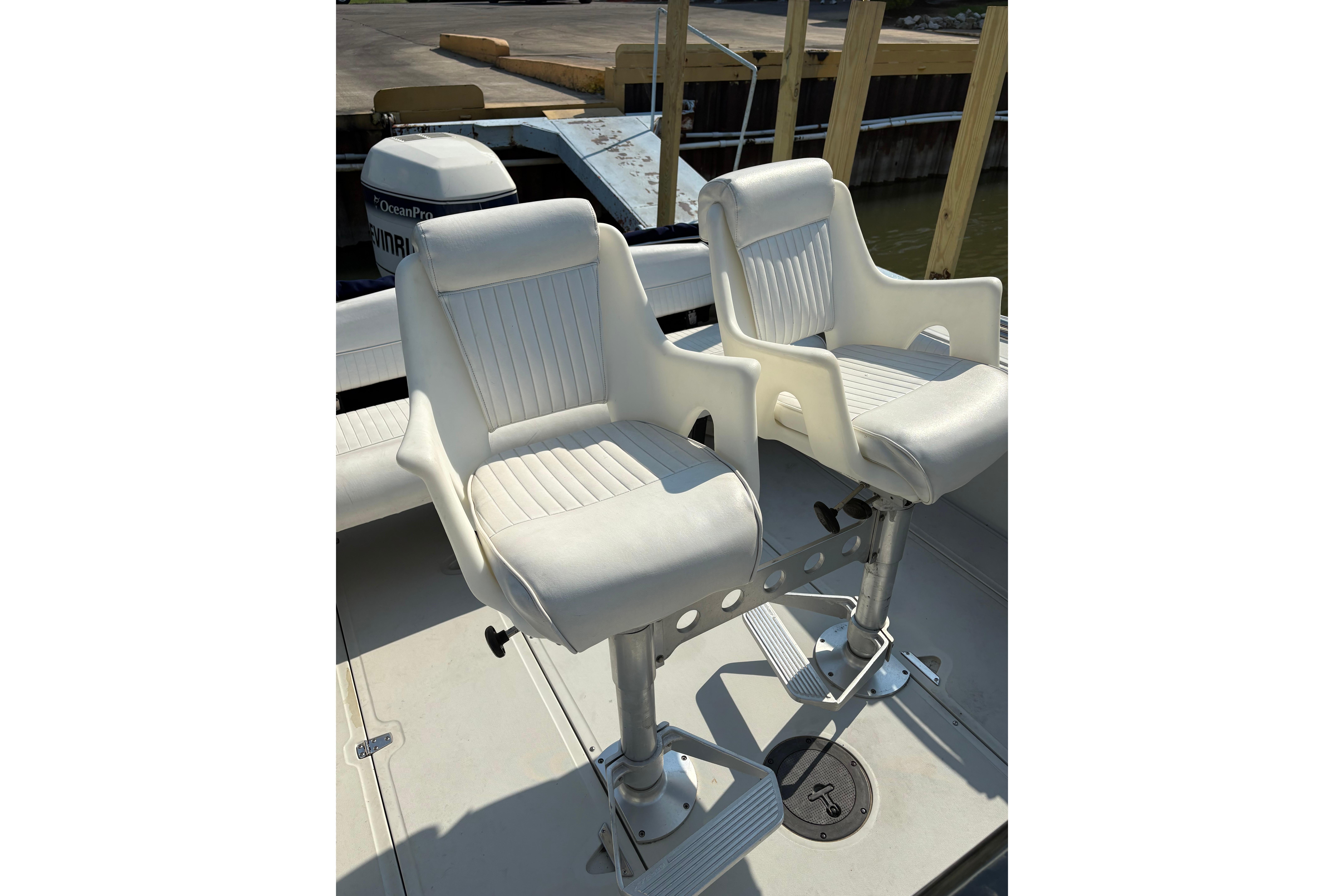 Two white swivel seats on a 1993 Boston Whaler 21 Outrage boat deck.