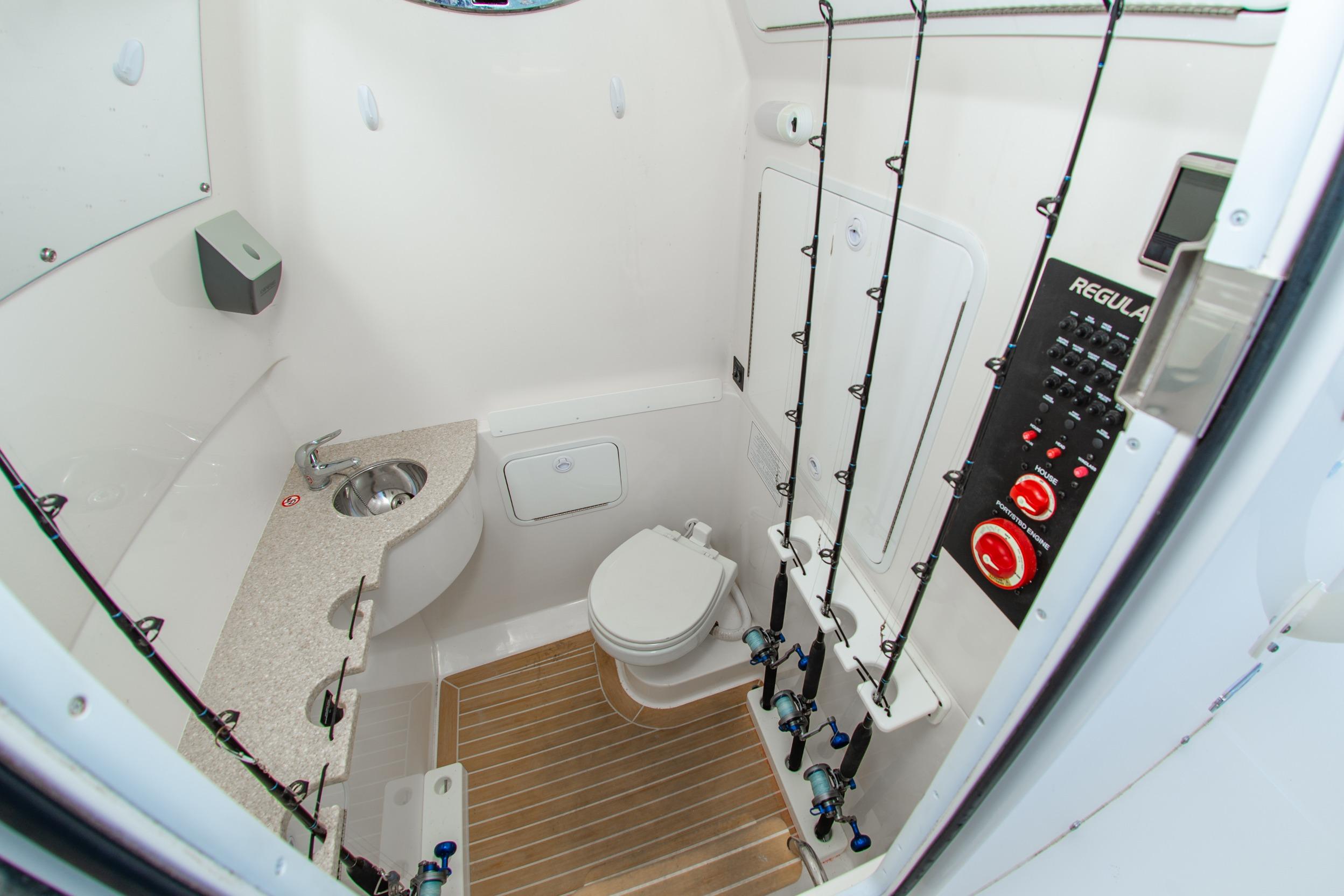 2019 Regulator 31 boat interior with bathroom, sink, and fishing rod storage.