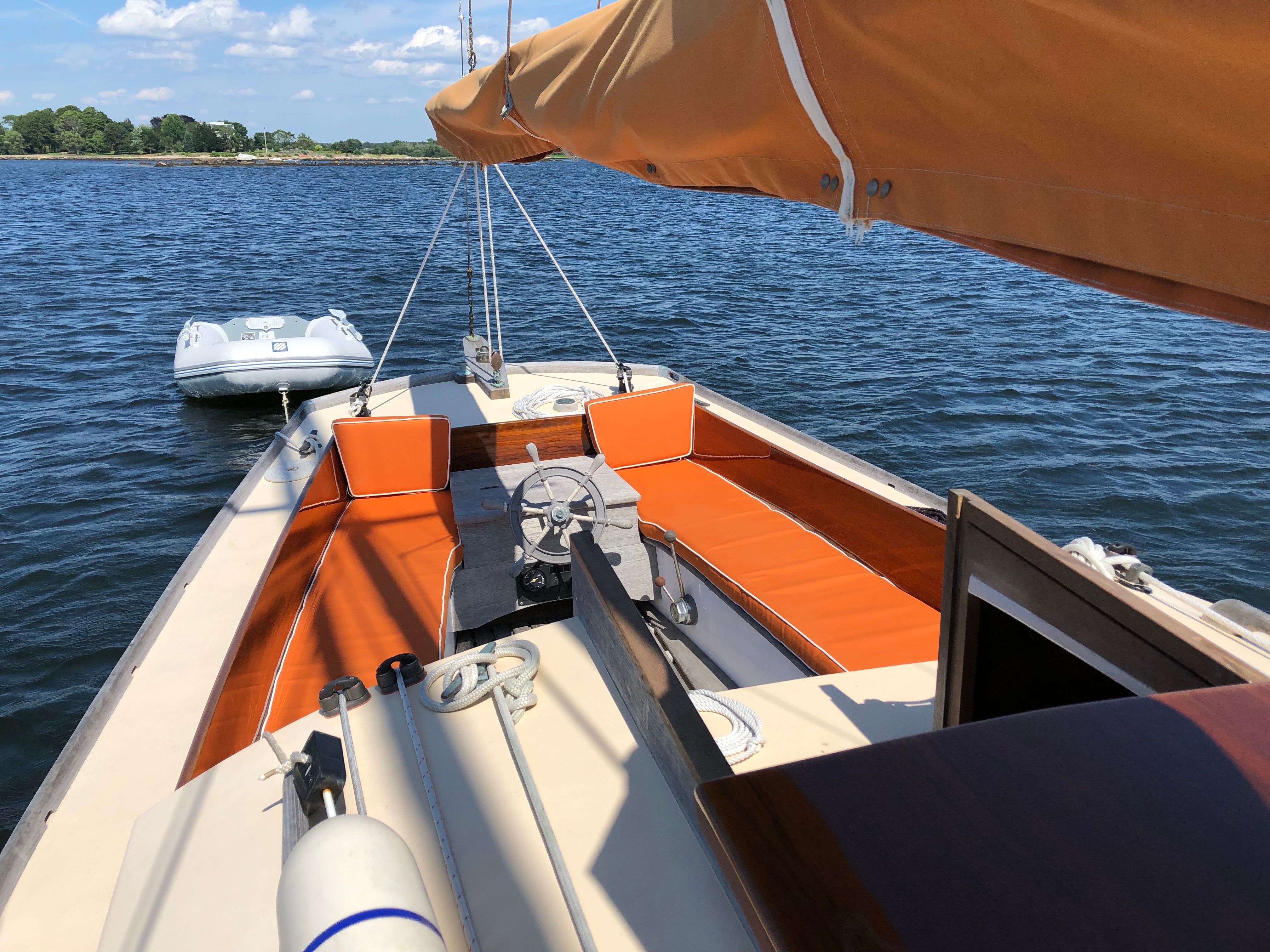 A 1973 Talman Yacht Menemsha-24 with orange cushions on the water.