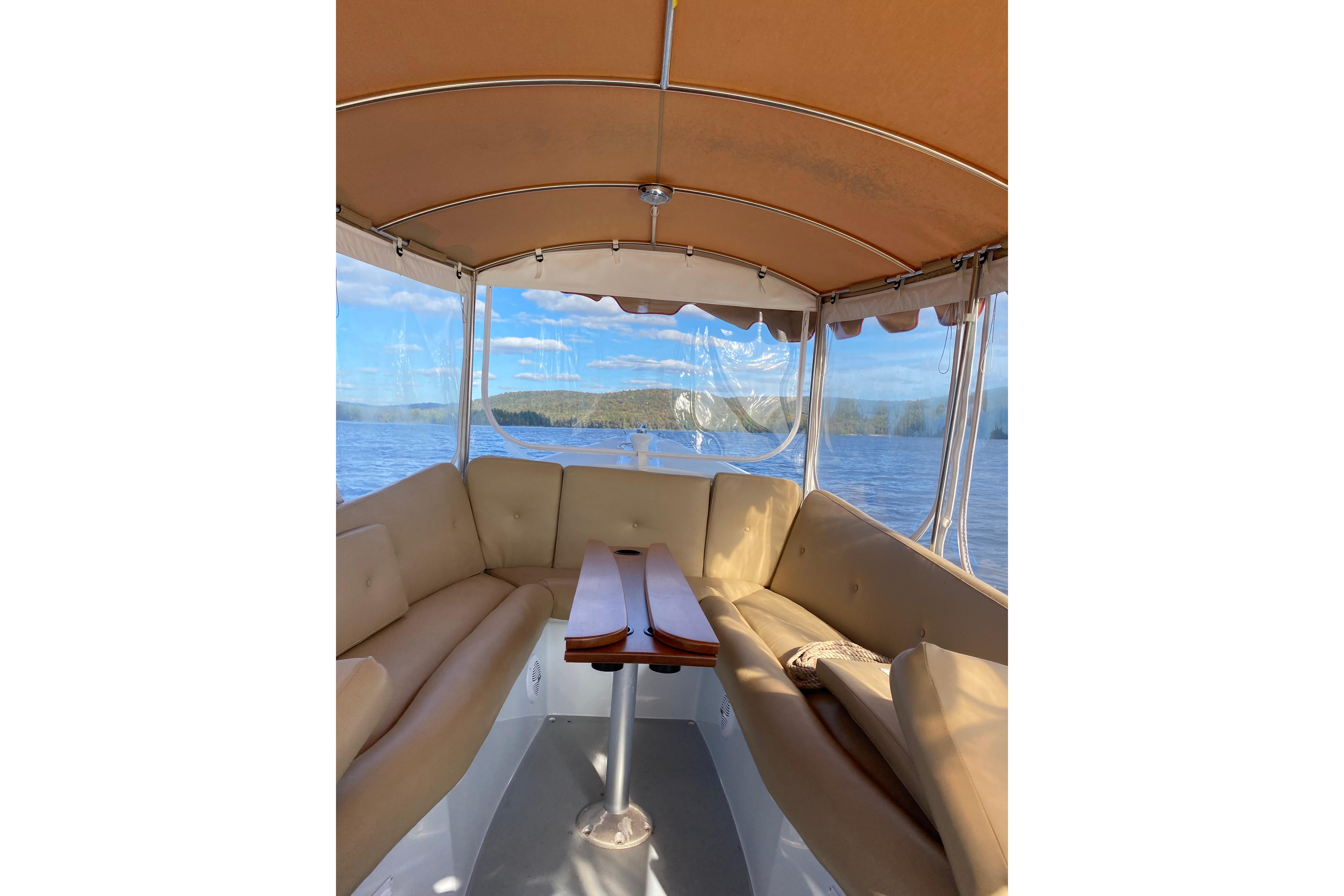 Interior view of a 2004 Duffy 21 Classic boat with beige seating and scenic water backdrop.