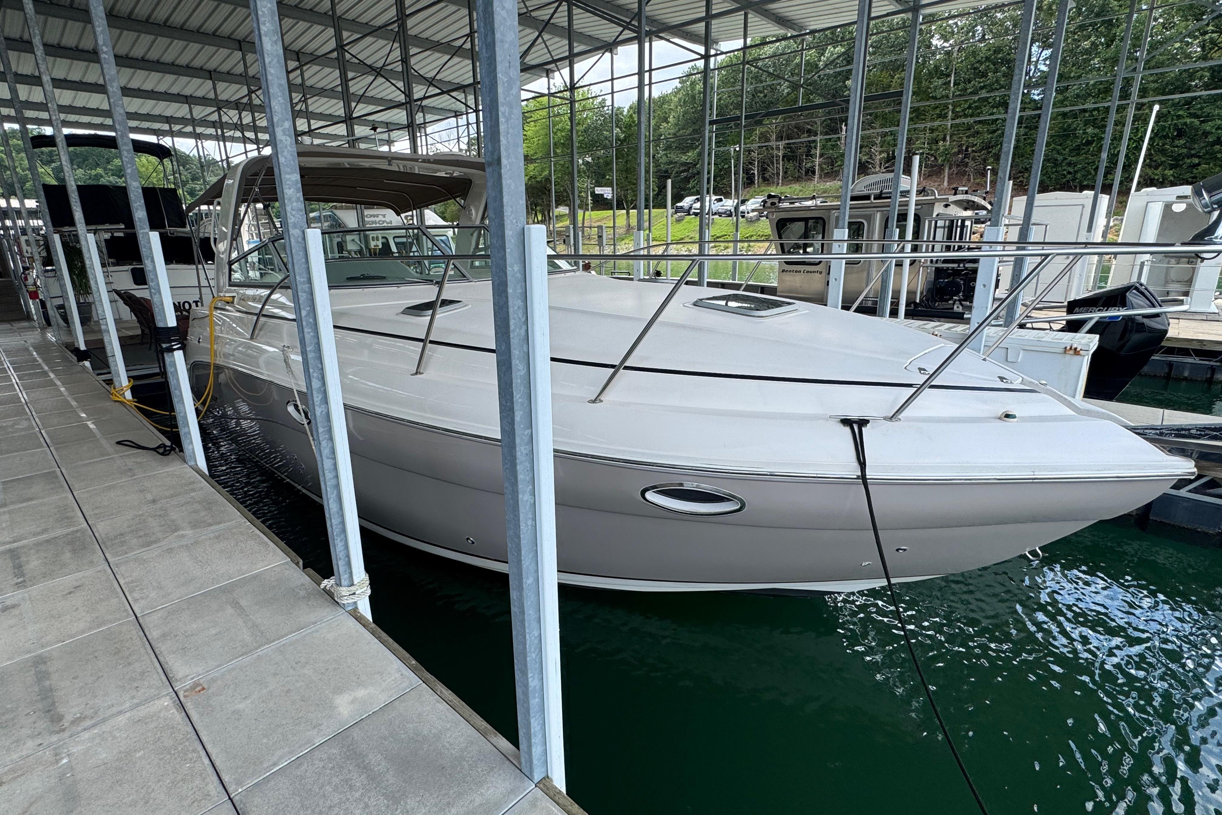 2004 Rinker Fiesta Vee 312 docked in a covered marina, side view.