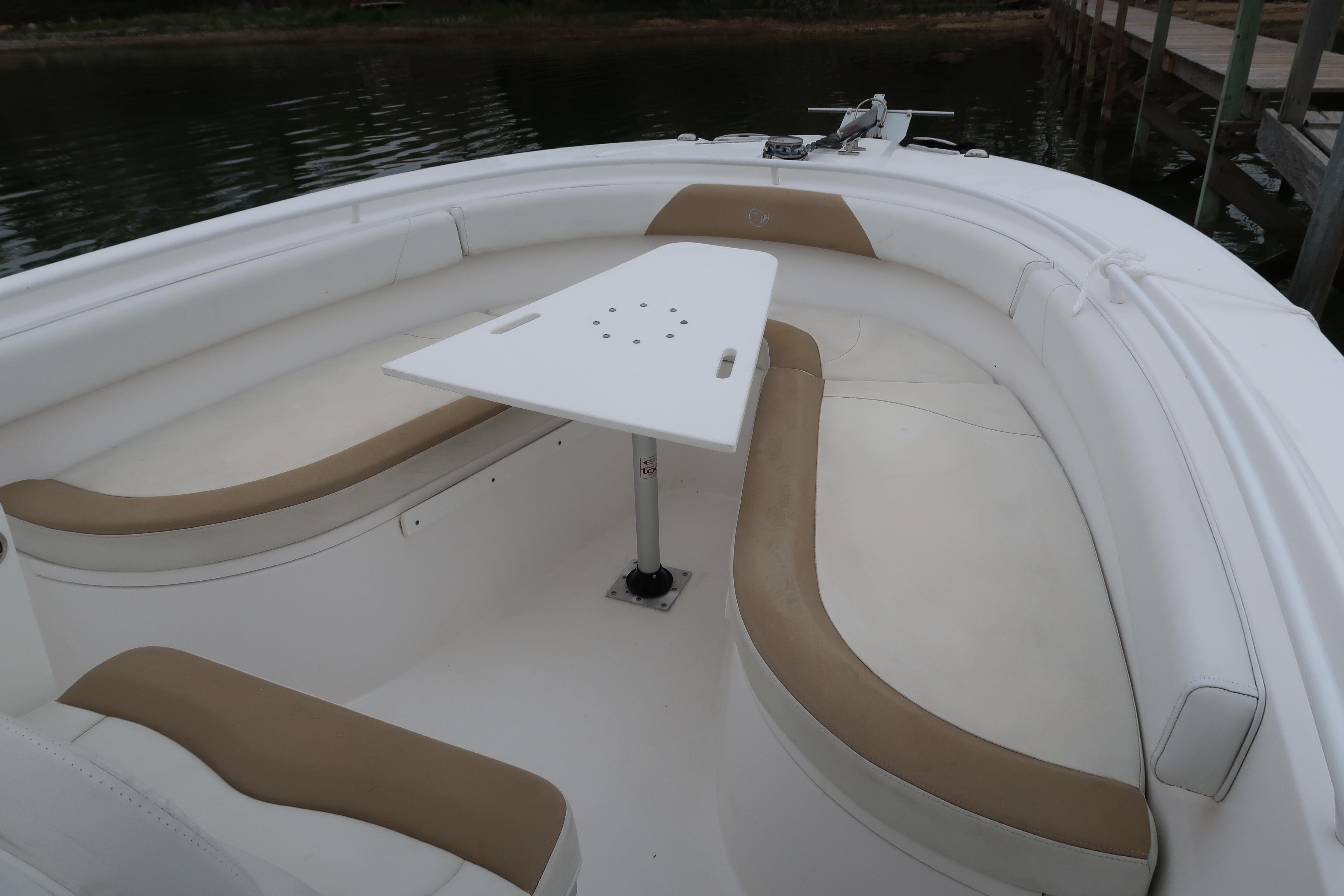 2017 Edgewater 245CC boat interior with cushioned seating and a central table.