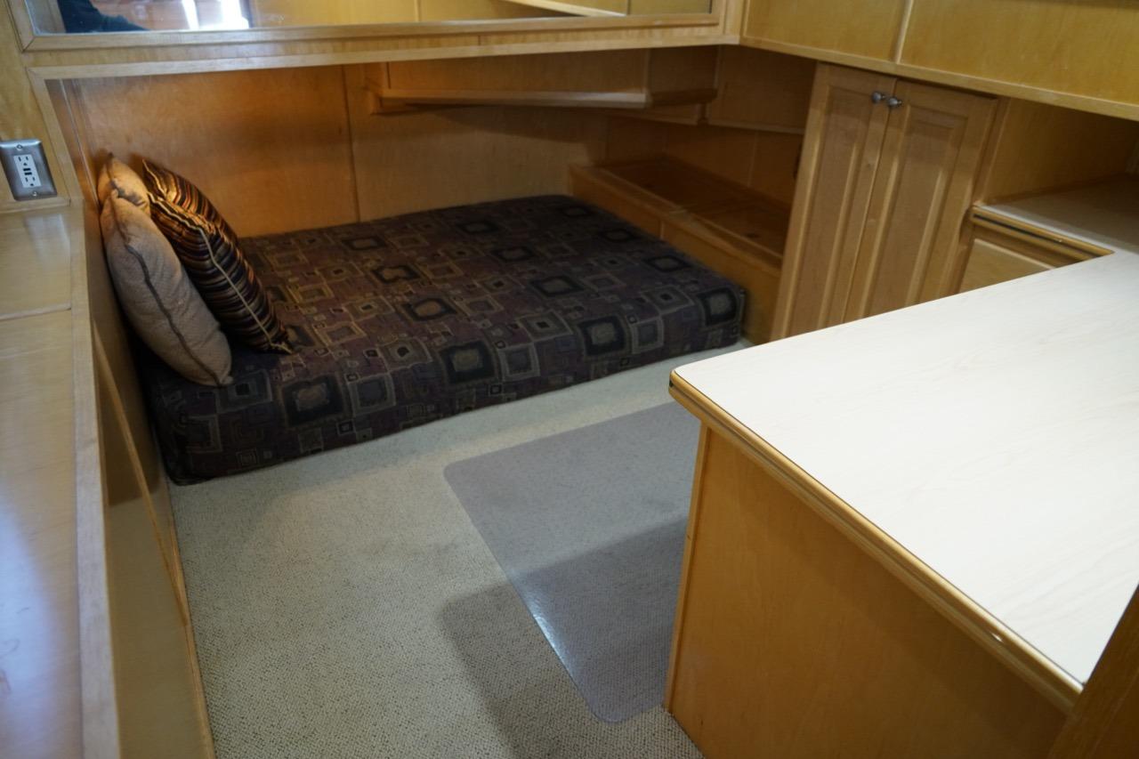 Cozy cabin interior of 2000 Stardust Cruisers houseboat with bed and wooden cabinetry.