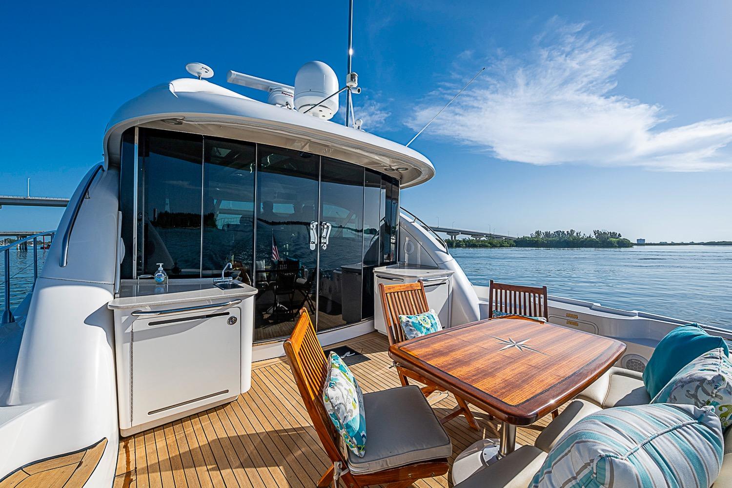 Luxurious 2008 Sea Ray 60 Sundancer yacht with elegant outdoor seating and scenic water view.