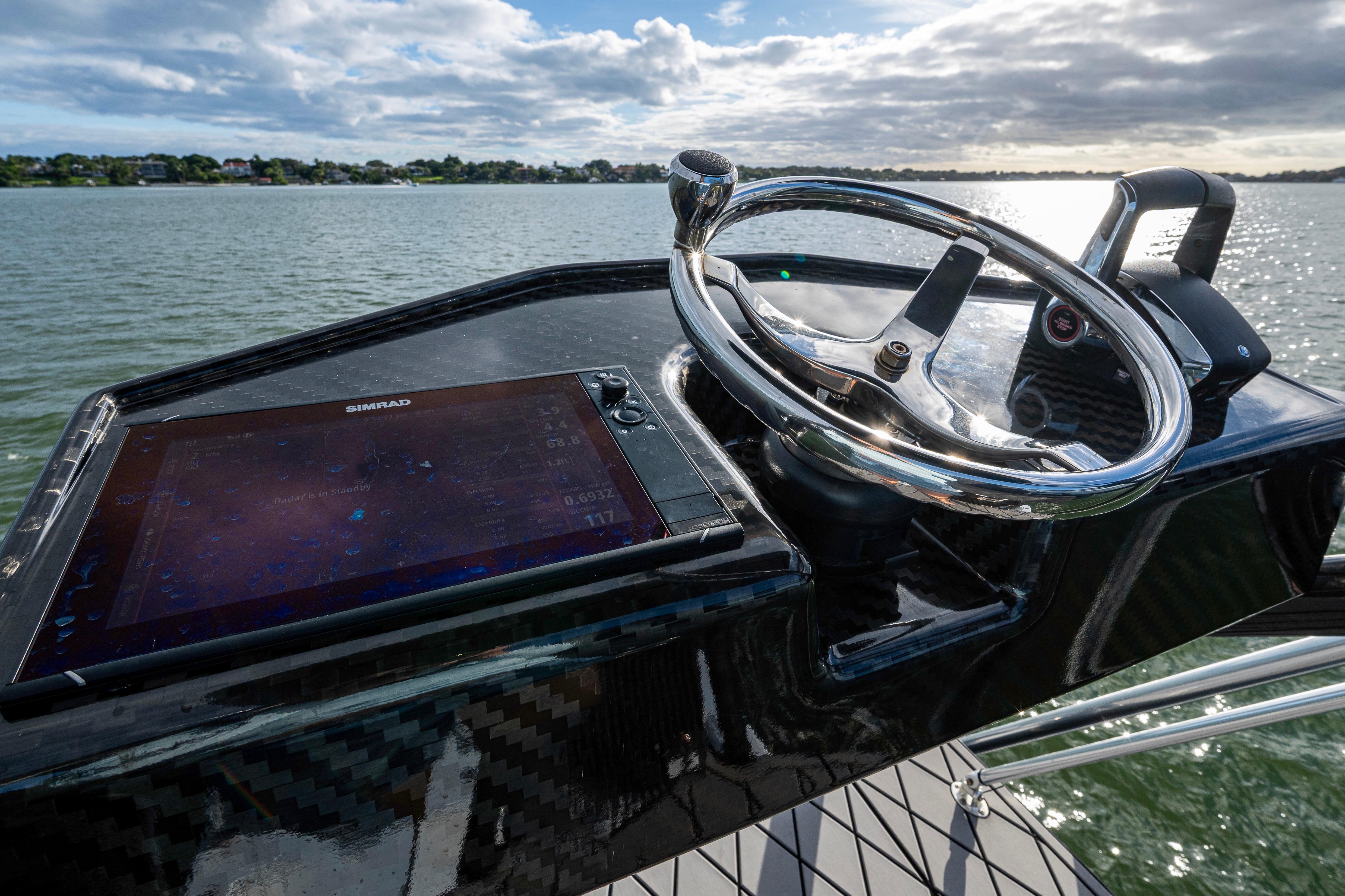 2024 Contender 44 ST boat helm with Simrad display on calm water.