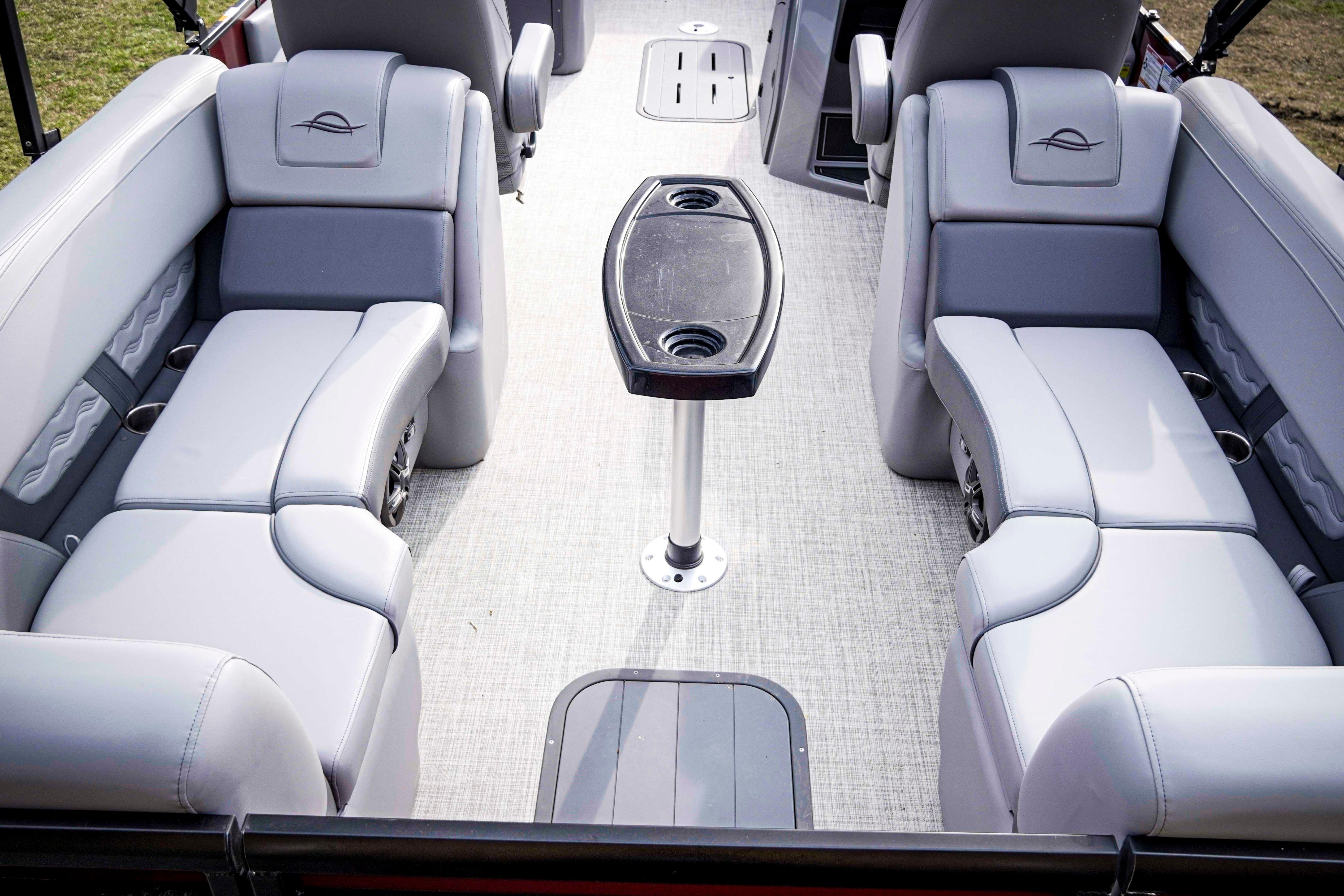 Luxurious seating area on 2025 SunCatcher Fusion 322RC pontoon boat with central table.