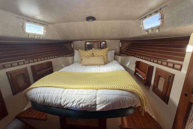 Cozy cabin interior of 1982 Lancer 45 Motorsailer with bed and wooden accents.