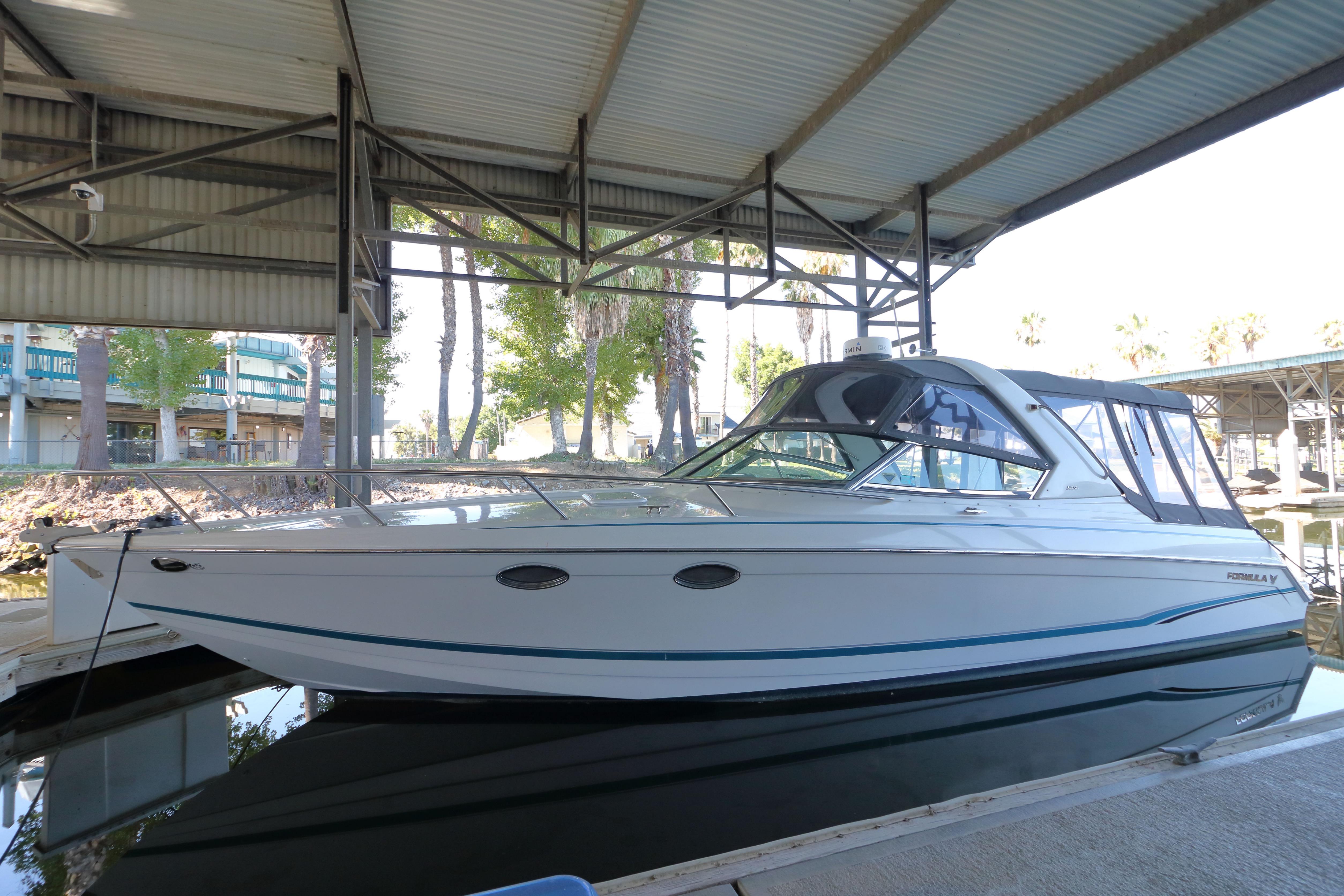 2006 Formula 330 Sun Sport boat docked under a covered marina.