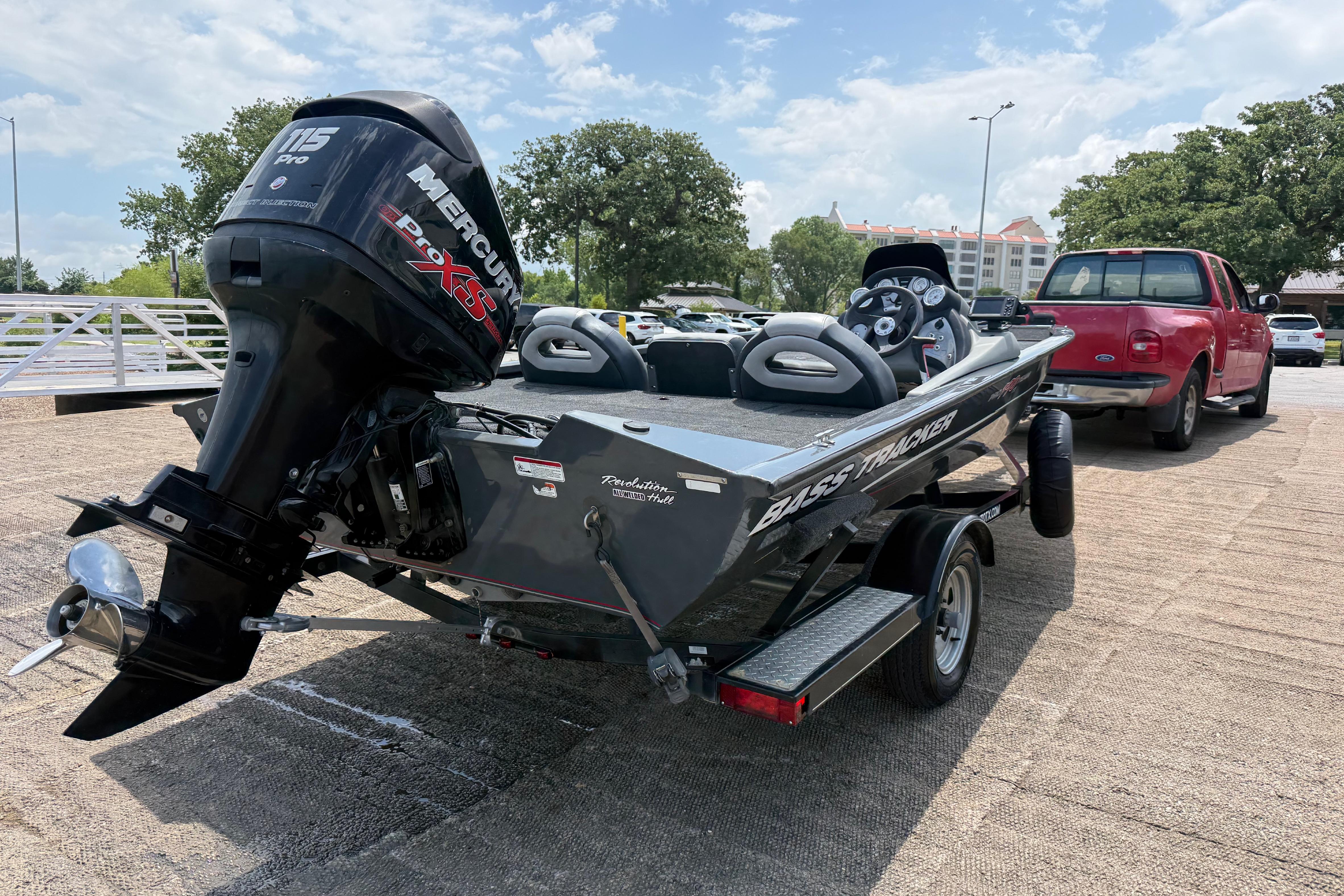 2015 Tracker Pro Team 190 TX boat on trailer, parked near a red truck.