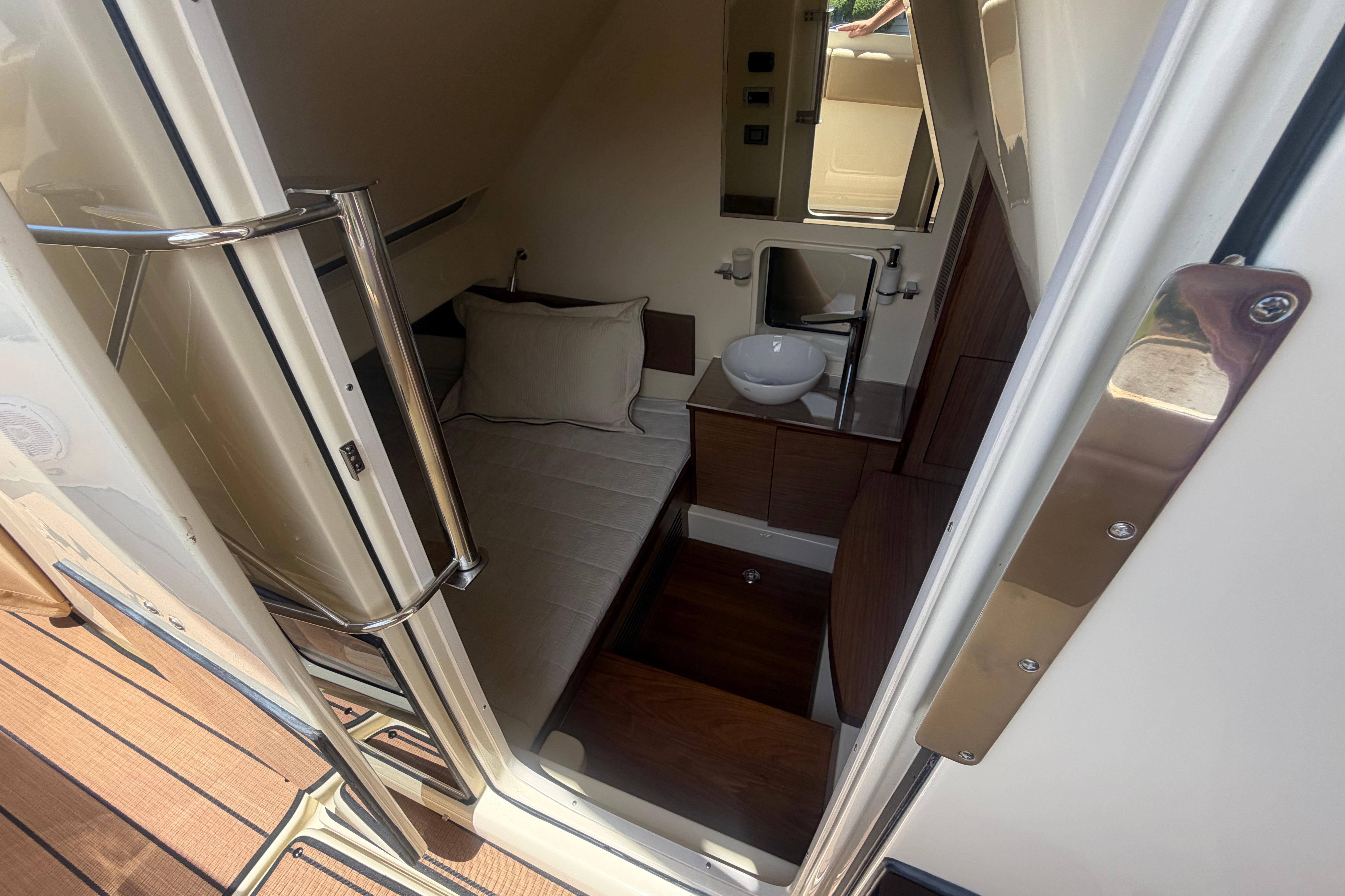 2017 Chris-Craft Catalina 34 cabin interior with bed, sink, and wooden accents.