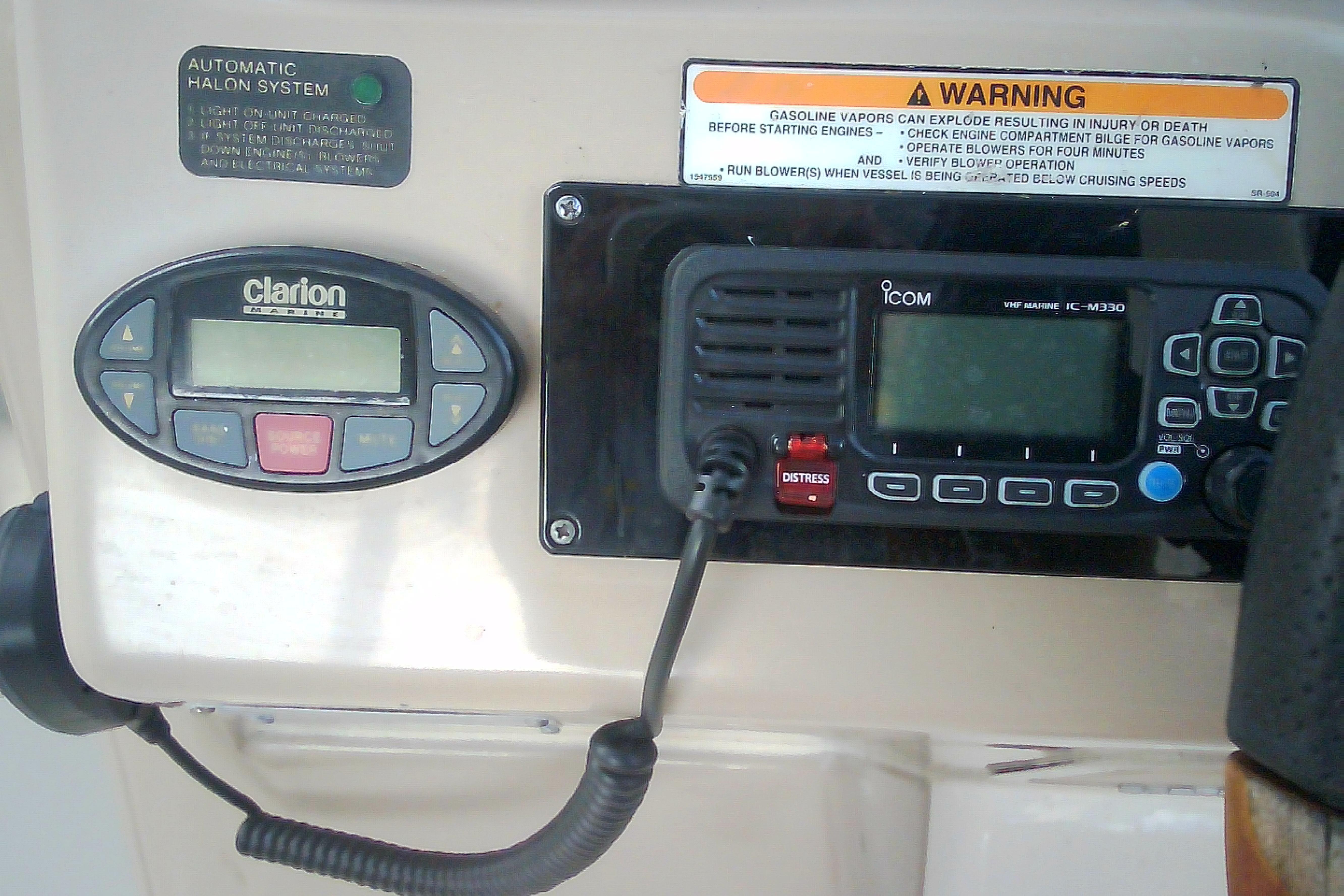 Control panel of a 2005 Sea Ray 300 Sundancer with radio and warning label.