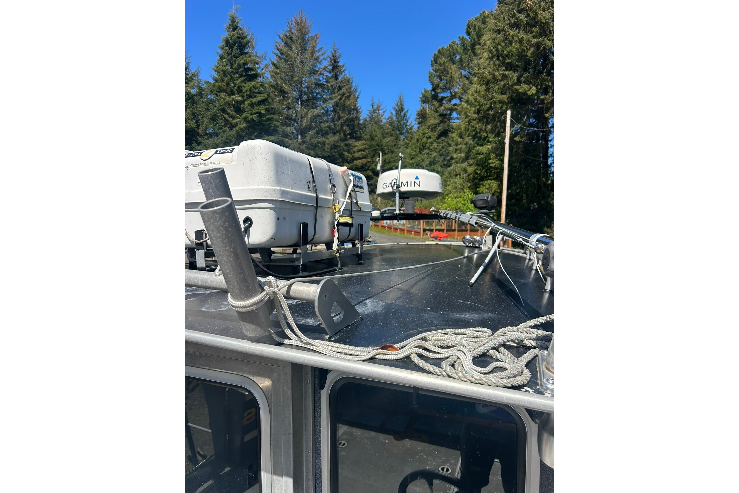 2016 North River 29 Offshore boat roof with Garmin equipment and ropes, surrounded by trees.