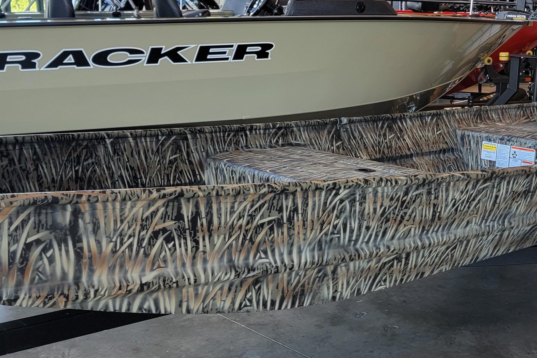 2026 Tracker Grizzly 15 Jon boat with camouflage design in showroom.