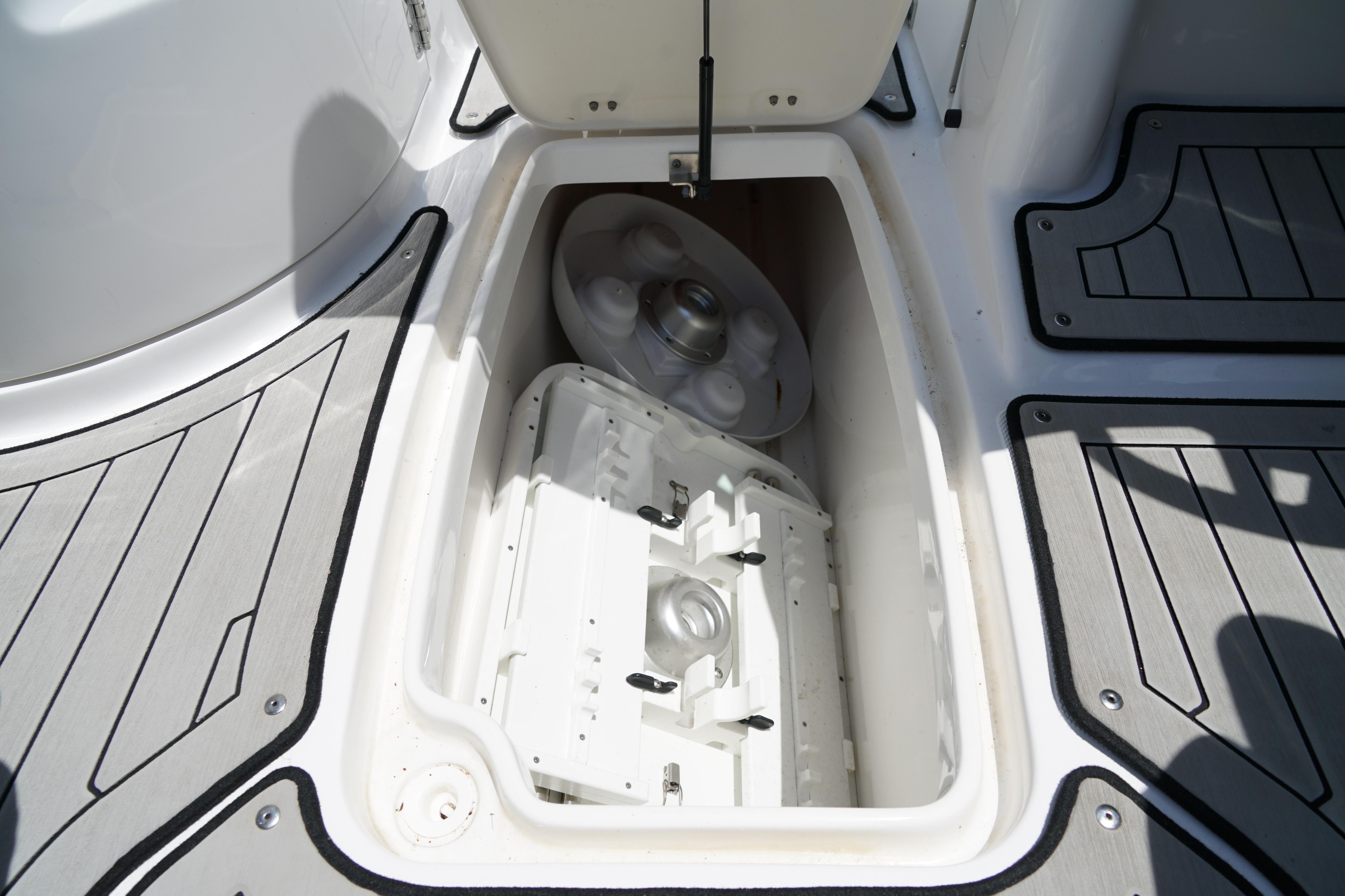 Storage compartment on 2020 Hurricane SunDeck 2486 OB boat, featuring sleek flooring design.