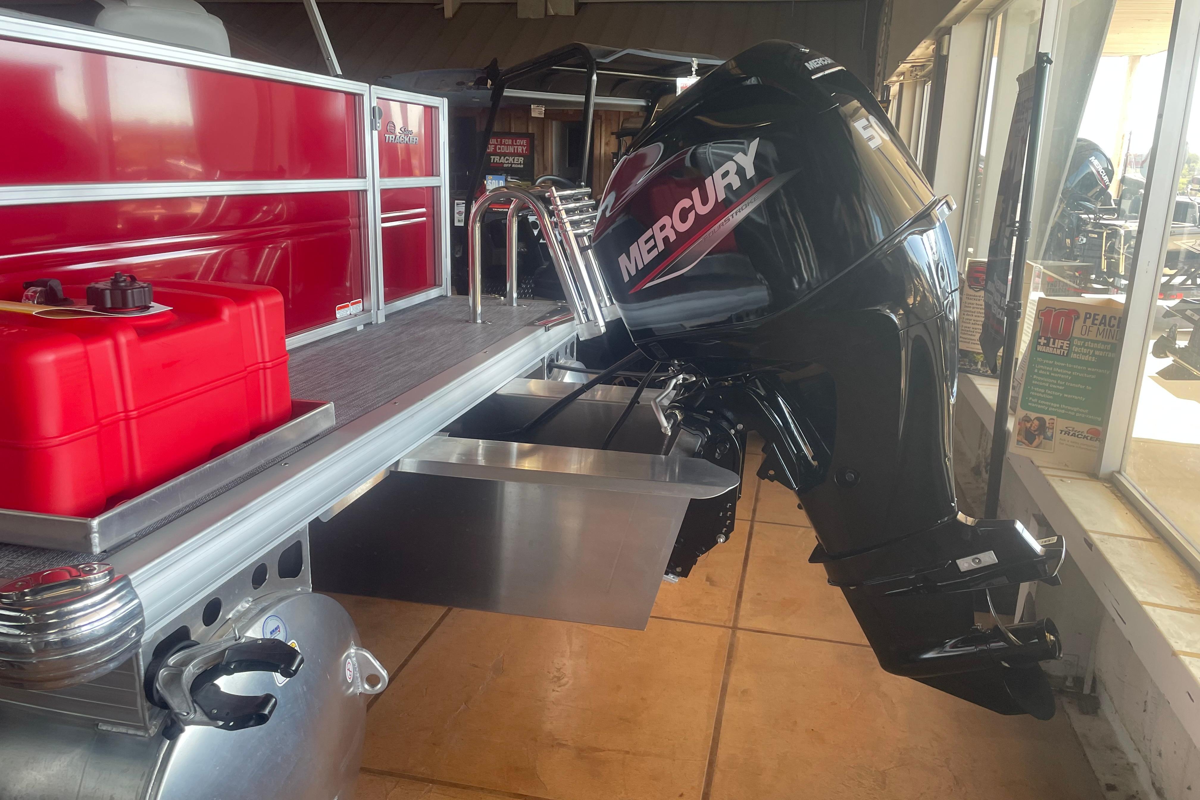 2026 Sun Tracker Party Barge 16 DLX with Mercury outboard motor and red fuel tank.