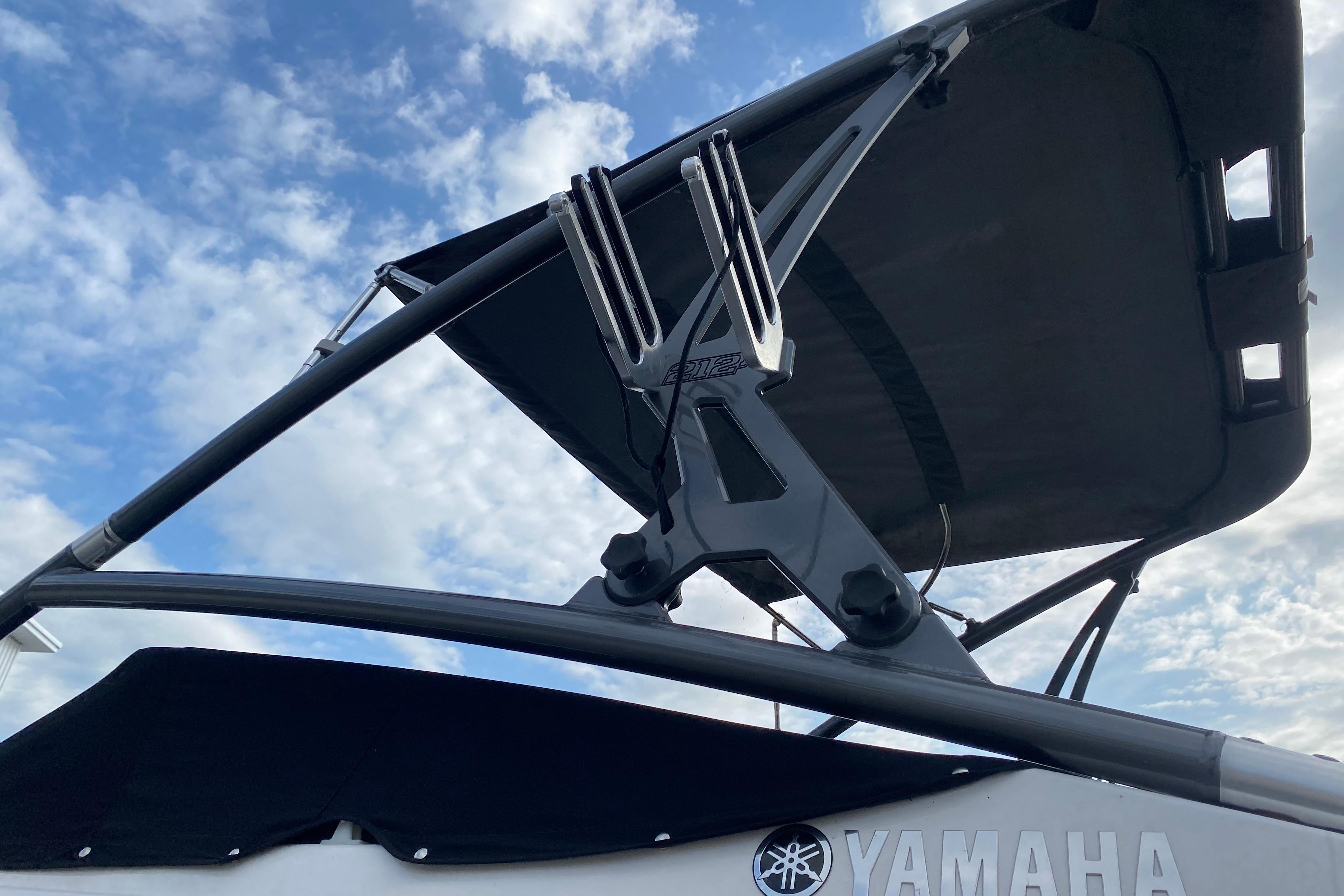 2015 Yamaha Boats 212X with wakeboard tower against a cloudy sky.