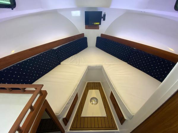 Interior of the 2015 Eastern 27 Islander with cushioned seating and a small table.